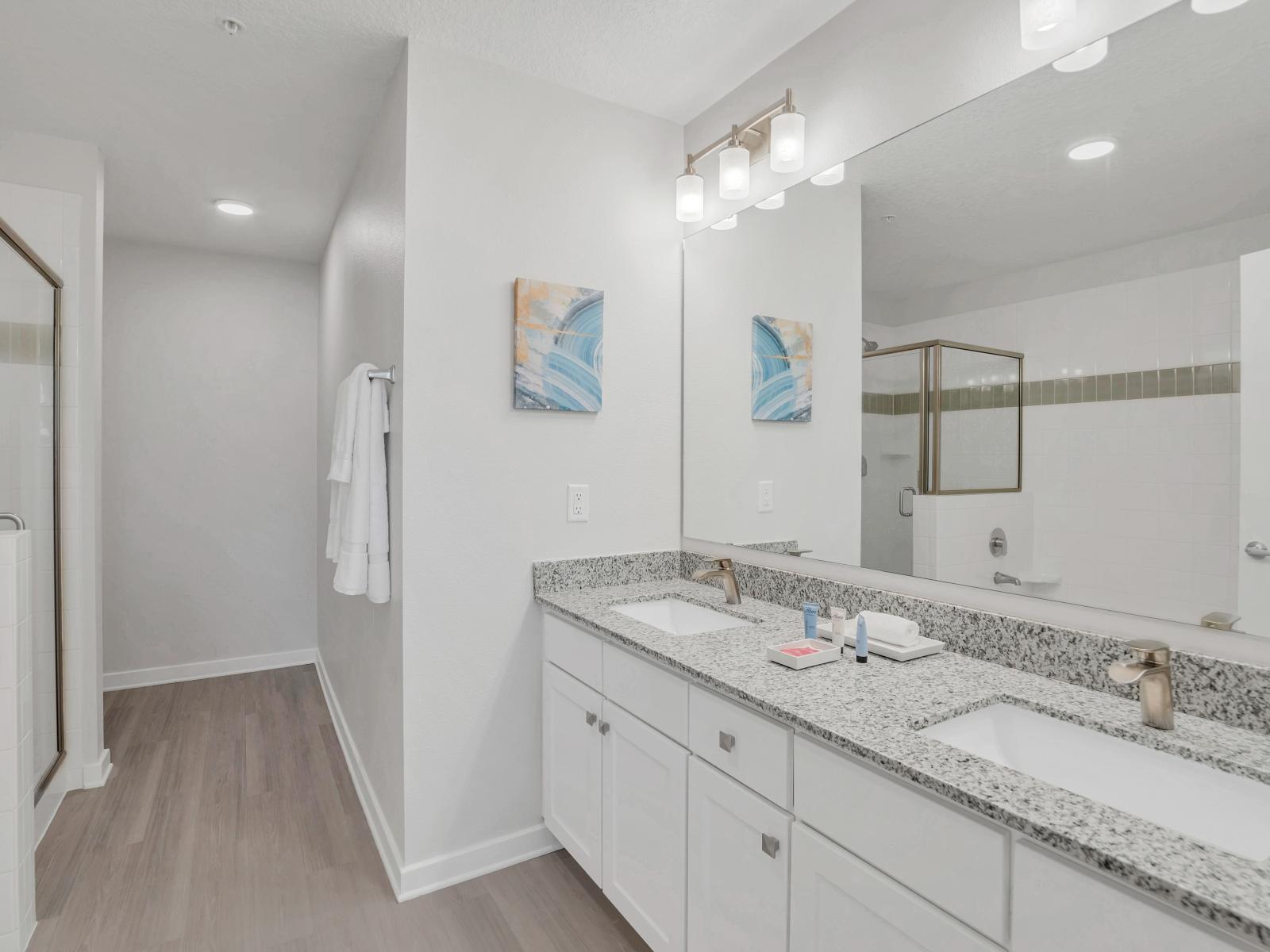 Polished bathroom of the condo in Orlando - Chic design featuring a sleek dual vanity and upscale lighting - Seamless design featuring a glass-enclosed shower for a modern touch