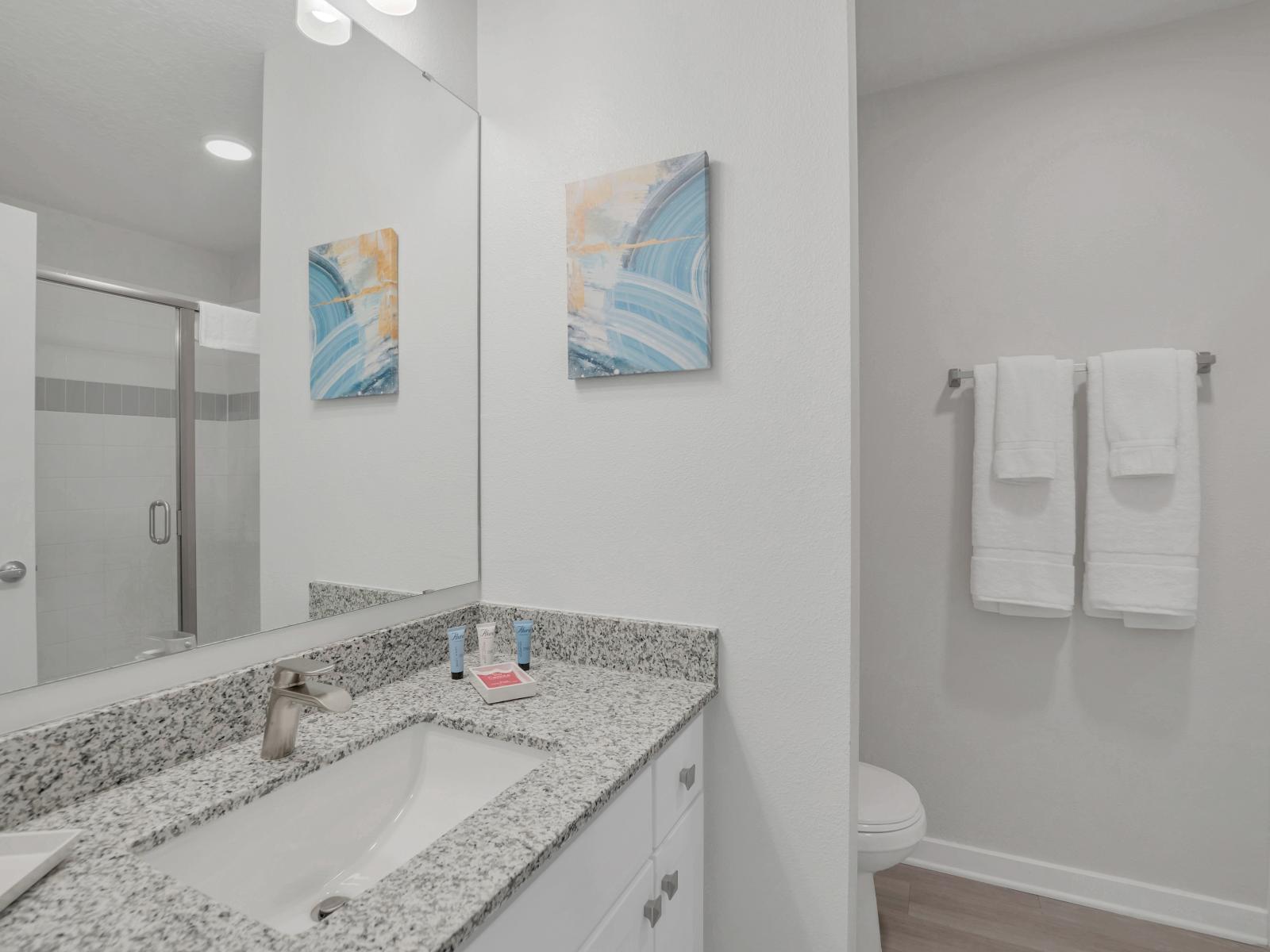 Exclusive bathroom of the condo in Orlando - Marvelous glass-enclosed shower area - Lush vanity with large mirror - Clean toilet seat