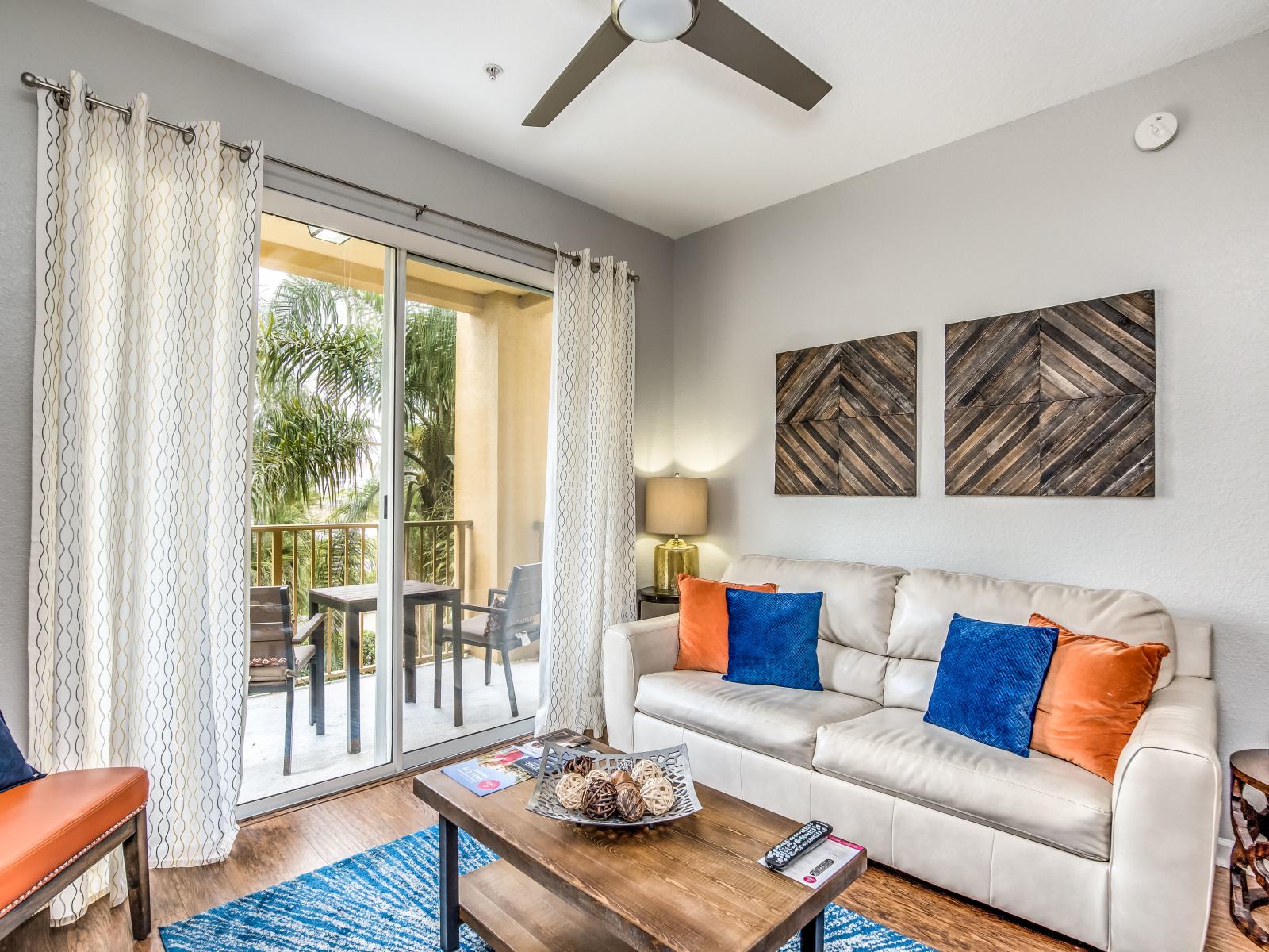 Inviting living area of the condo in Orlando where comfort meets style. - Majestically decored space with beautiful wall paintings - Relax on comfy sofas after a day full of adventure - Magnificent balcony facing living area with views