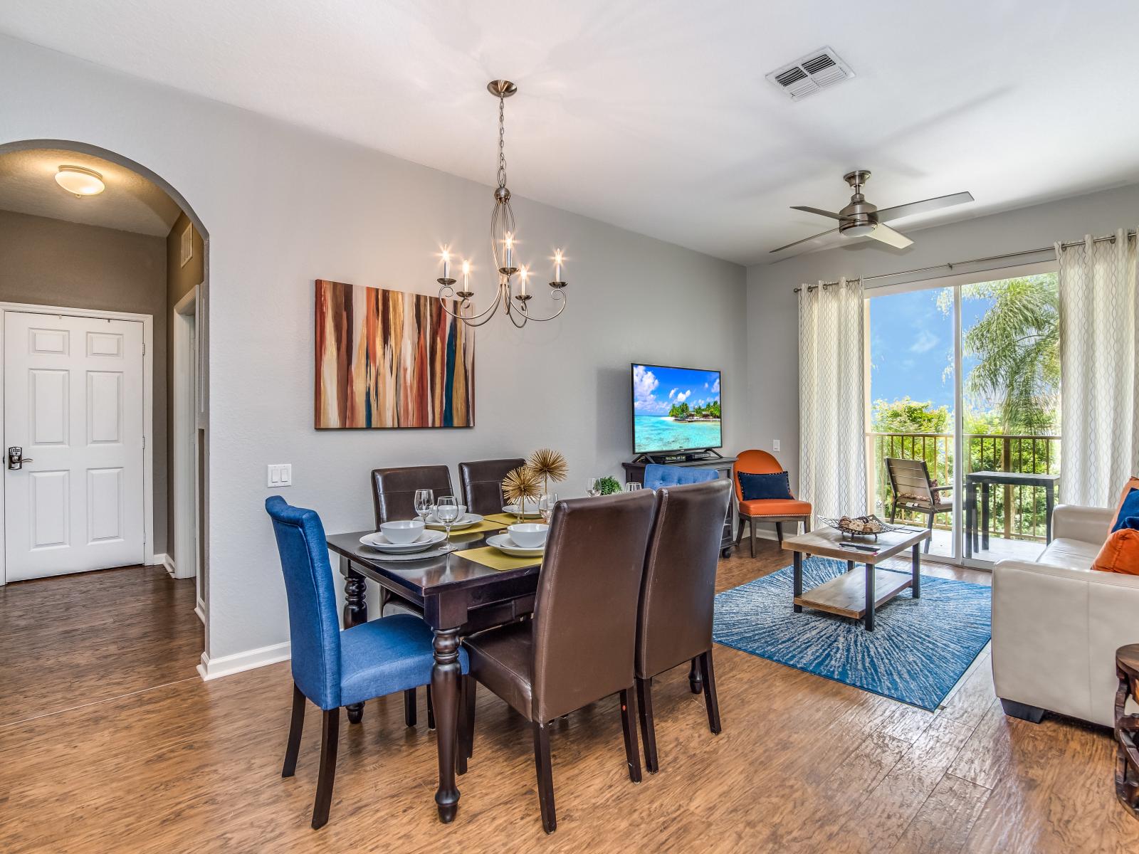 Gloriously designed Dinning area connected with living area of the condo in Orlando - Stunning 6 persons dinning - Cozy sofas to relax - Large glass doors that leads to the private balcony of the condo - Availability of TV and Netflix