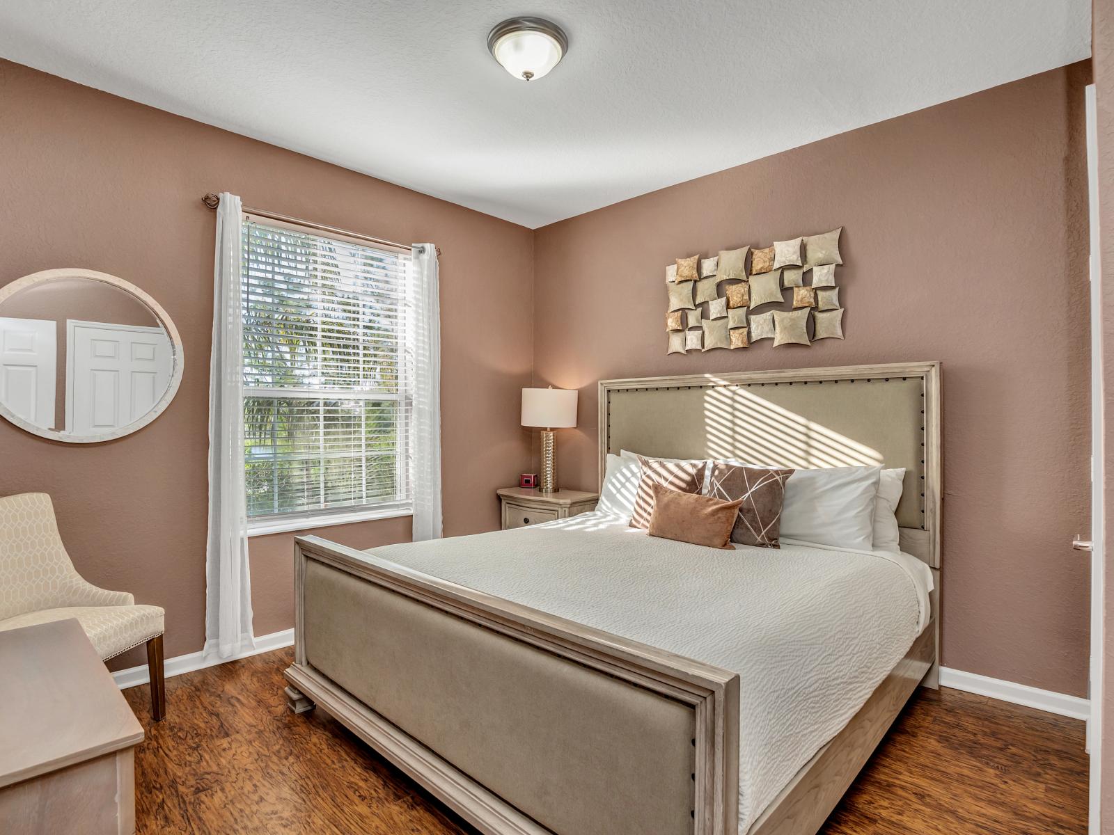 Exquisite main bedroom of the condo in Orlando - Comfortable king-size bed with neat and clean linen and a cozy sofa chair - Magnificent bedside window with mesmerizing views - Majestic decor - Stunningly wooden furnished floor