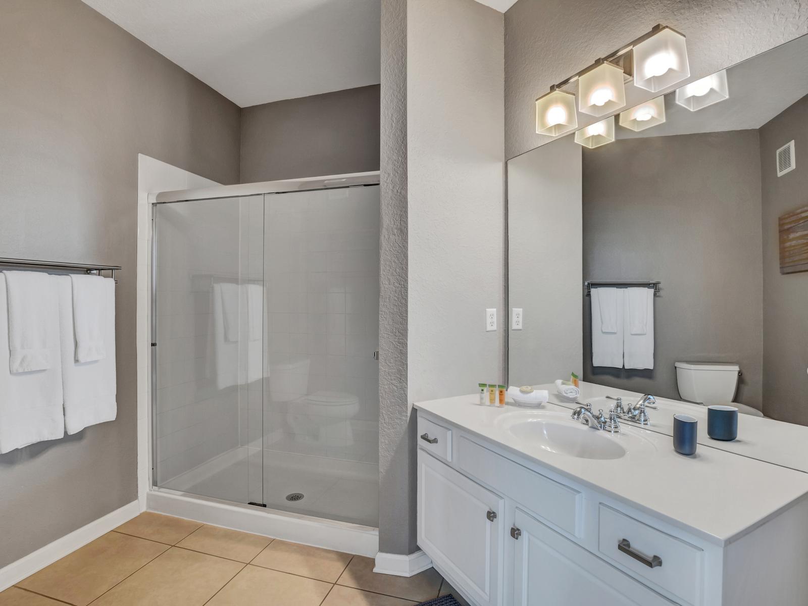 Experience luxury with the main en-suite bathroom of the condo in Orlando - Boasting a spacious walk-in shower. - Designed marvelously with glorious vanity with wall mirror and storage space - Fresh towels and all amenities available