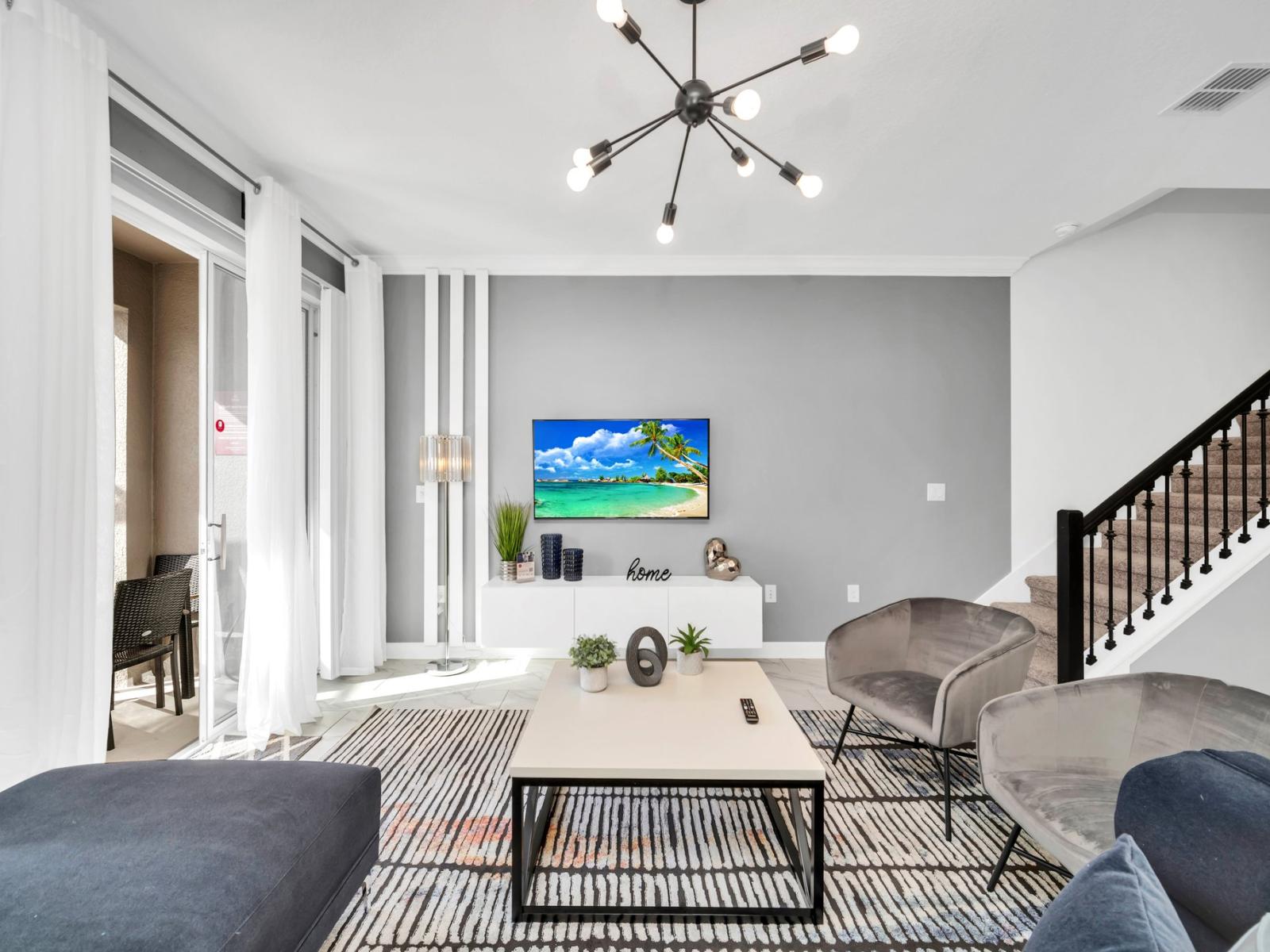 Enchanting living area of the townhouse in Kissimmee Florida - Stylish furniture arrangement providing comfort and a cohesive look - Easy access to outdoor with seating and pool - Well-chosen lighting fixtures adding both functionality and charm