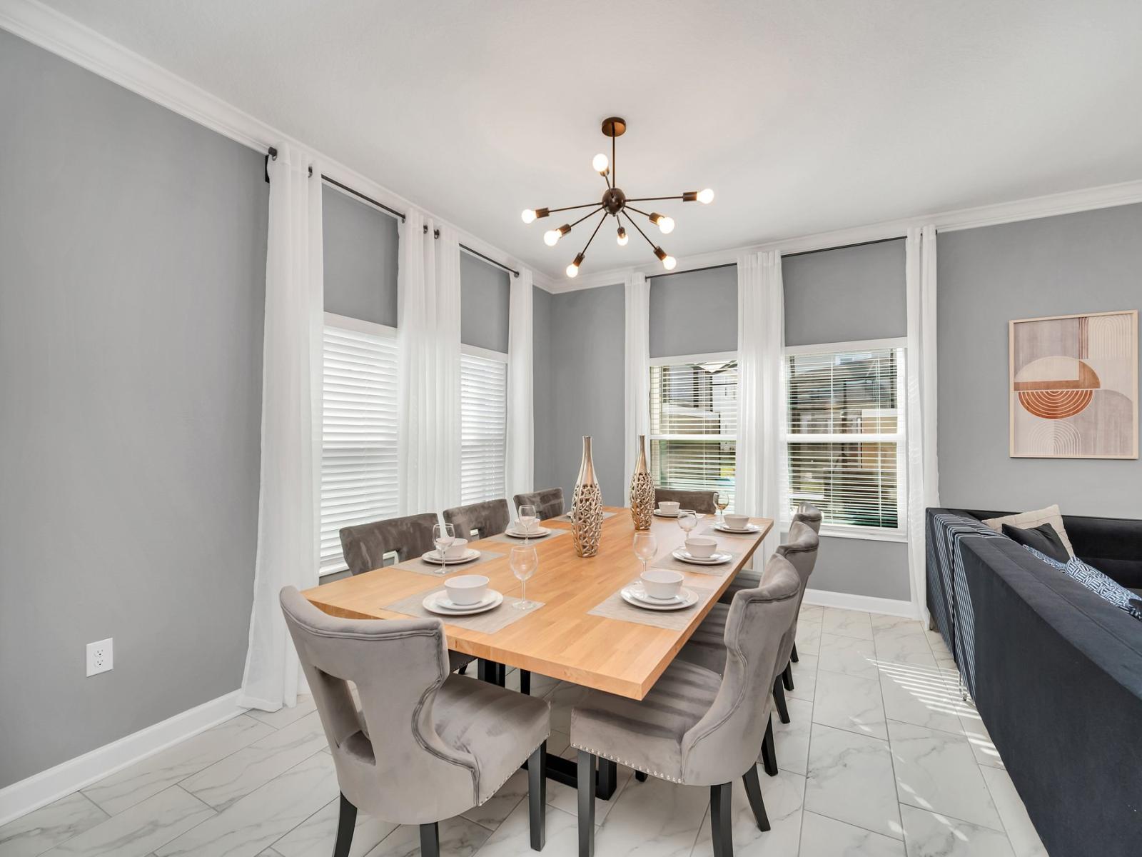 Gather around the banquet-style dining table, which comfortably seats 8 people. This inviting space is perfect for enjoying delicious meals, engaging in lively conversations, and creating lasting memories with family and friends.