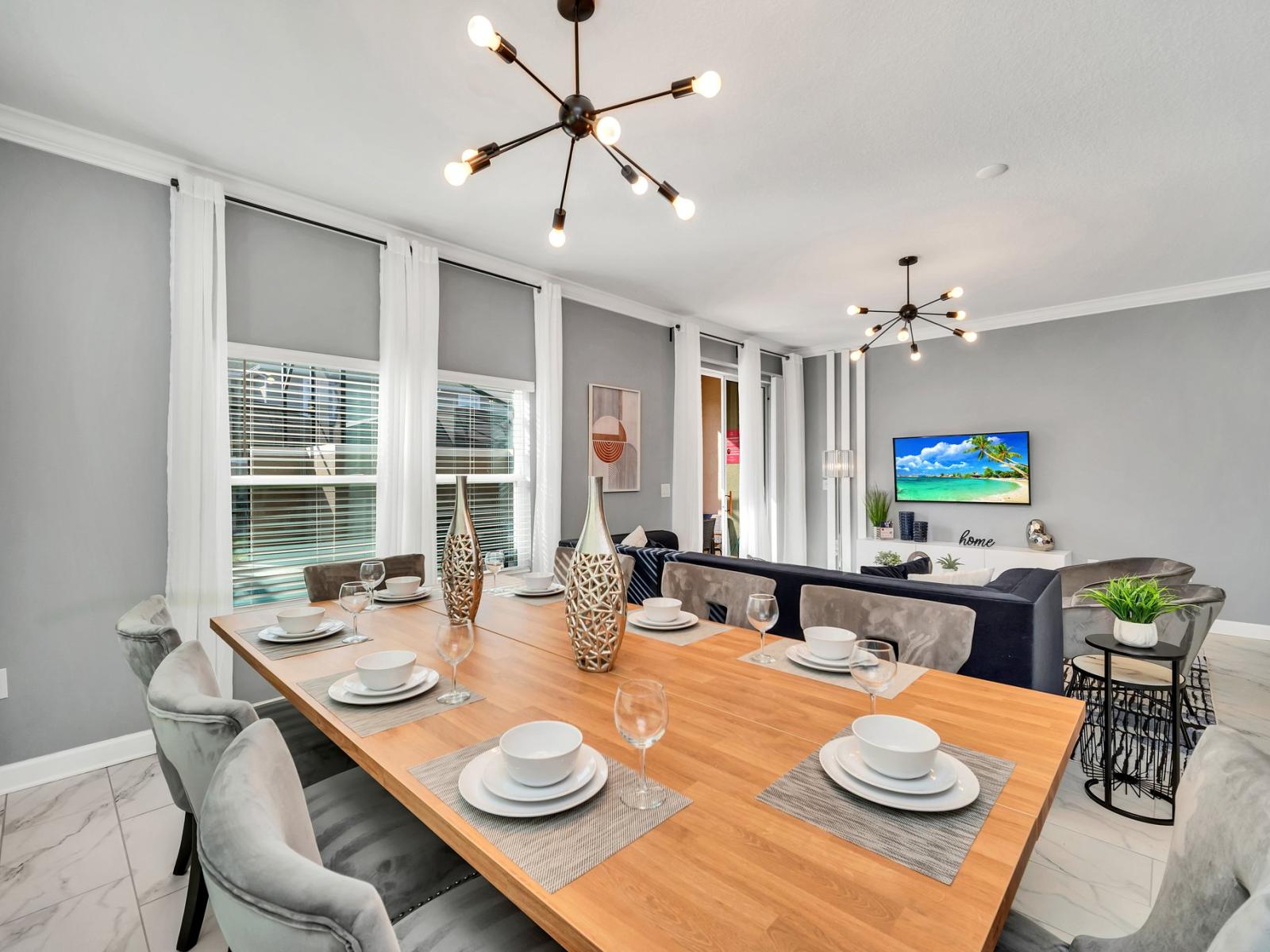 Elegant dining area of the townhouse in Kissimmee Florida - Chic dining area featuring a stylish table and contemporary seating - Open layout seamlessly connecting the dining area to the kitchen and living room - A statement chandelier lighting