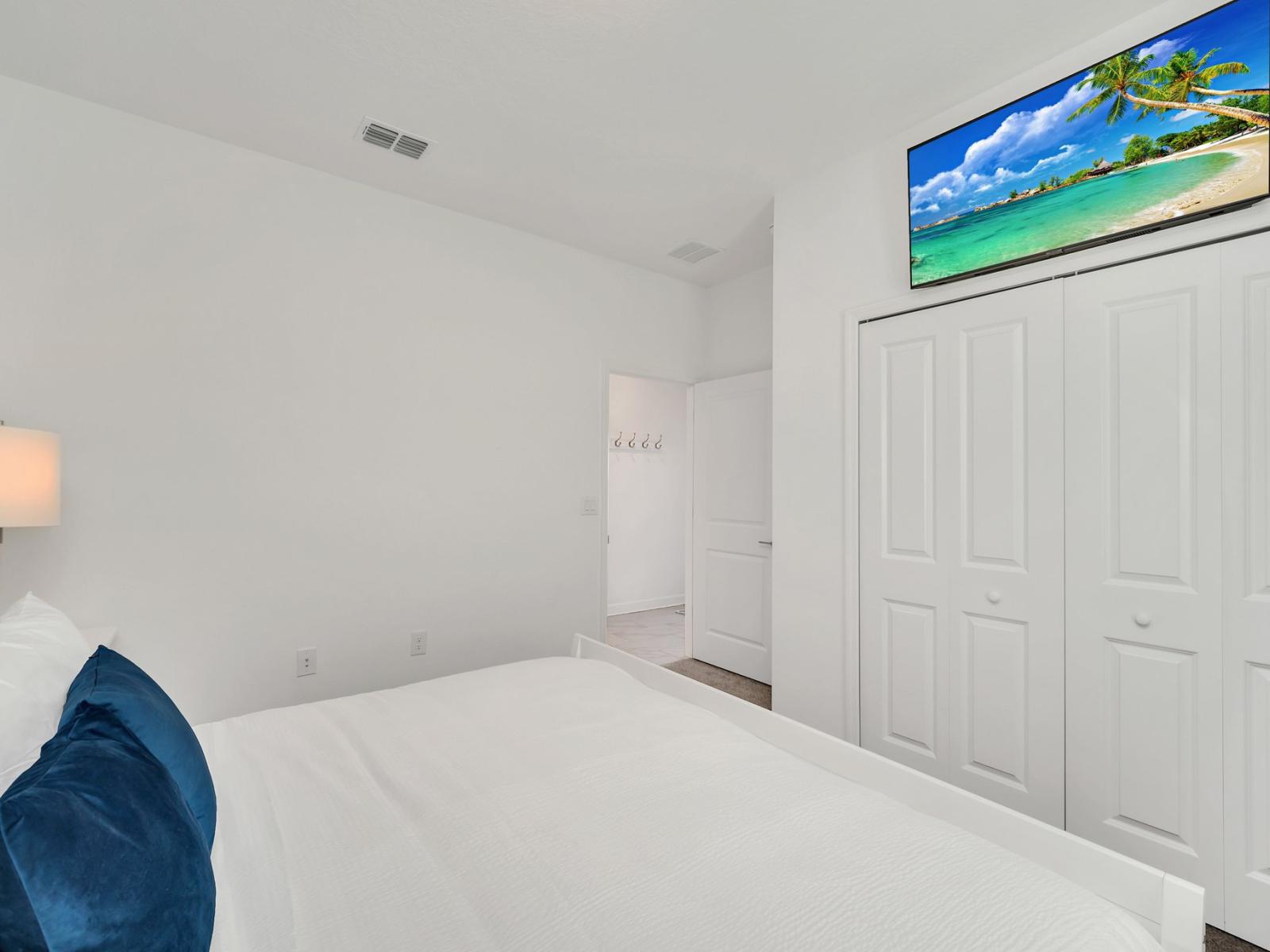 This serene bedroom is adorned with inviting wall decors and  blue accent pillows, adding a touch of calmness and elegance to the space.