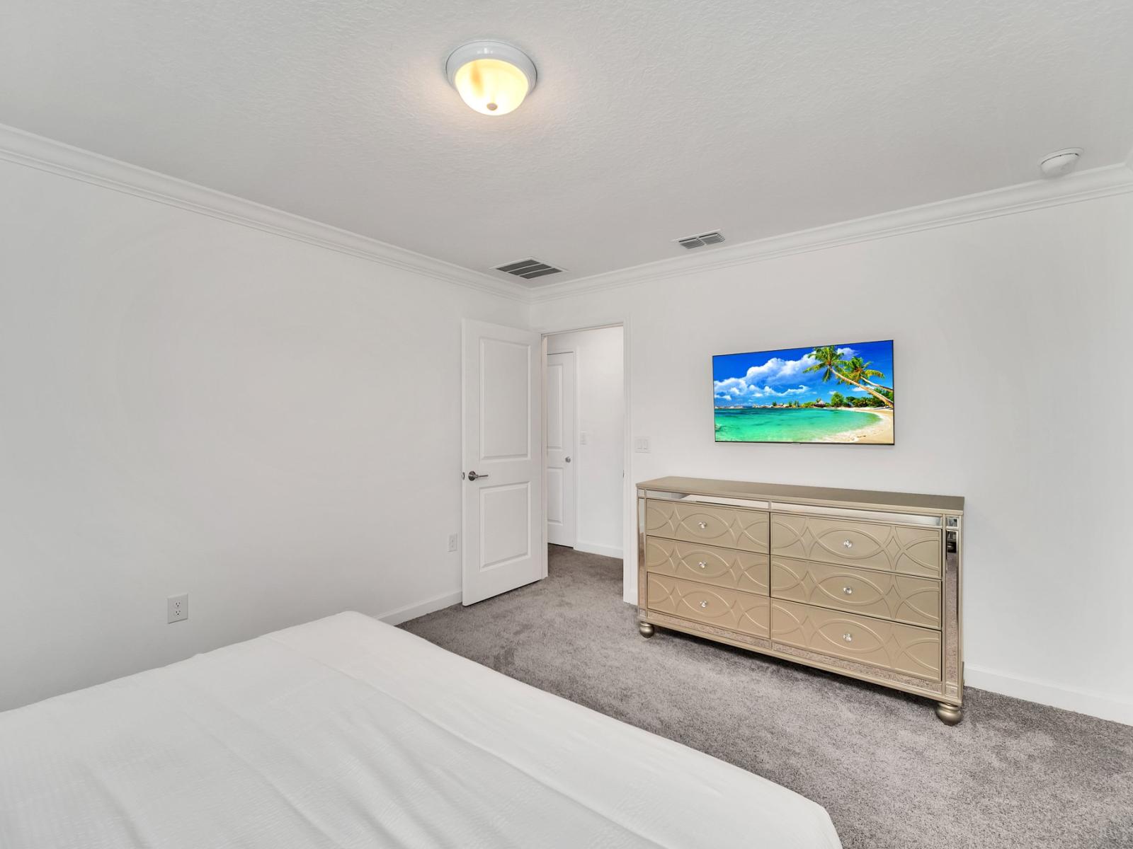 This serene bedroom boasts soothing blue accent walls and its own attached toilet and bath, offering a private retreat within the comfort of your own space.