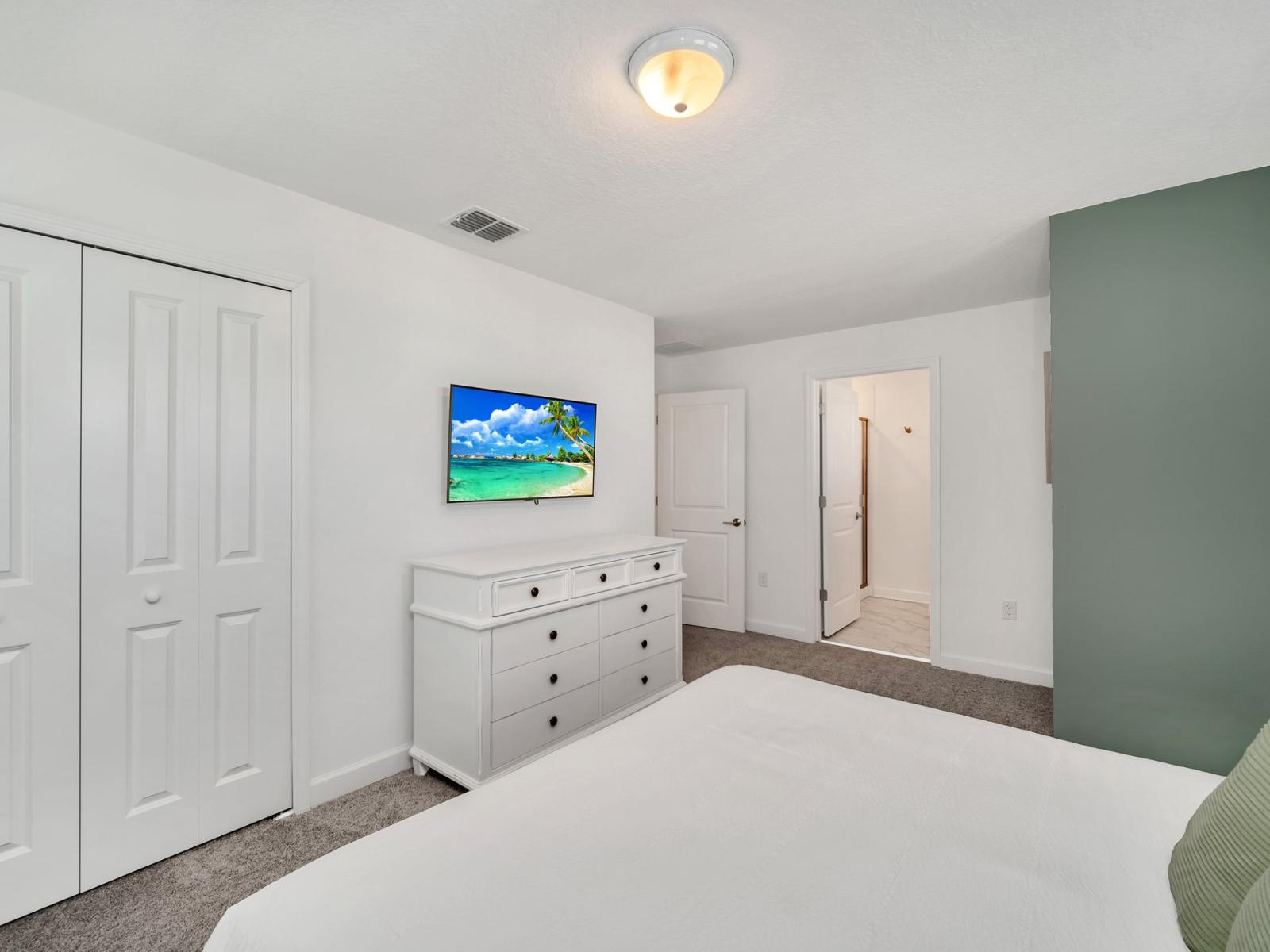 The bedroom features a sleek gray bedframe, adding a contemporary touch to the room's decor and creating a serene atmosphere for rest and relaxation.