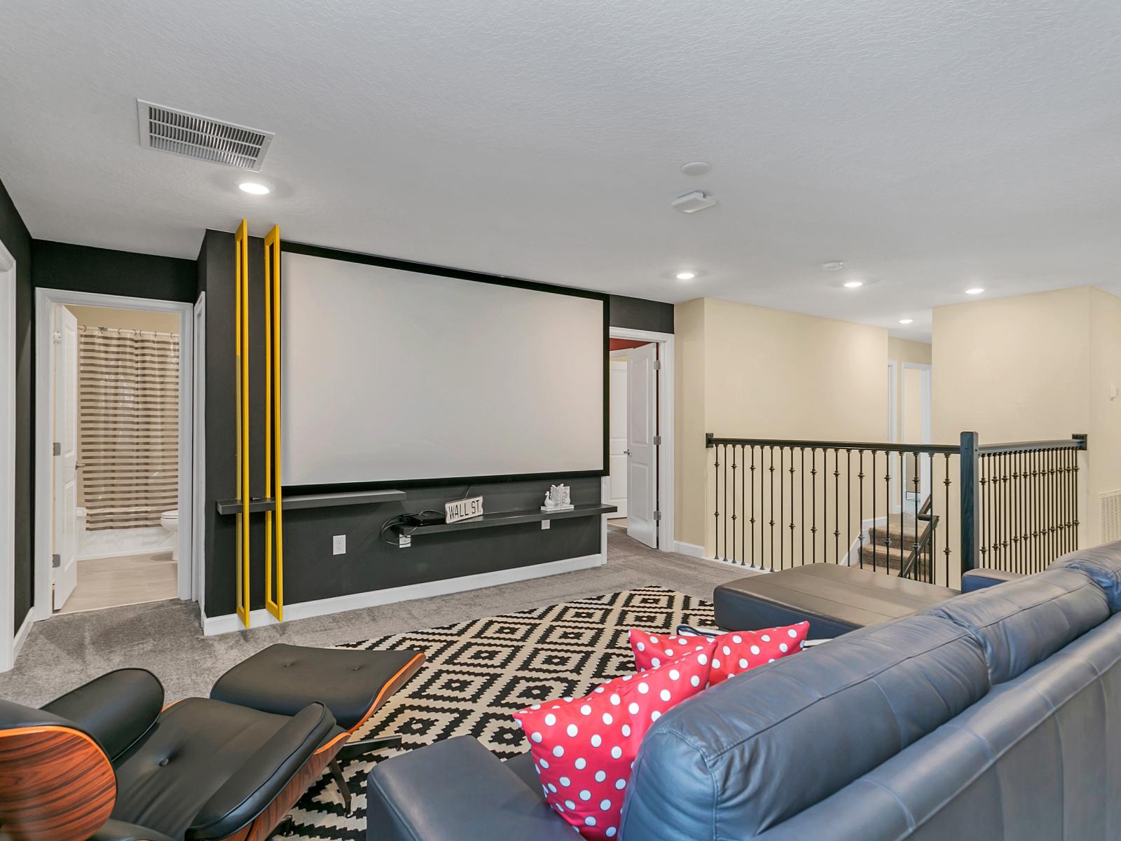 Chic living area of the home in Kissimmee Florida - Features a projector with large screen for movie nights - Plush and comfortable seating arrangements - Thoughtfully curated space with a warm and welcoming atmosphere