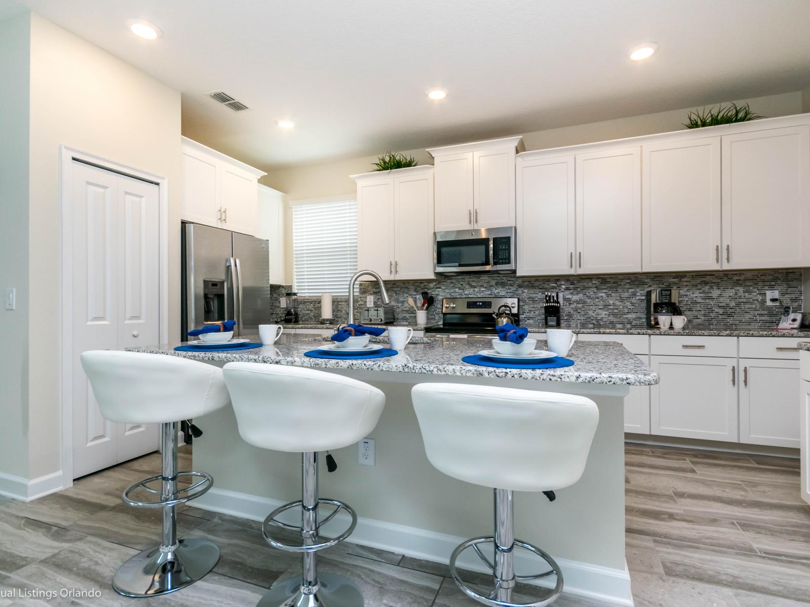 Cook, dine, and connect: Our open kitchen layout with a countertop table and highchairs invites shared meals and memorable moments.