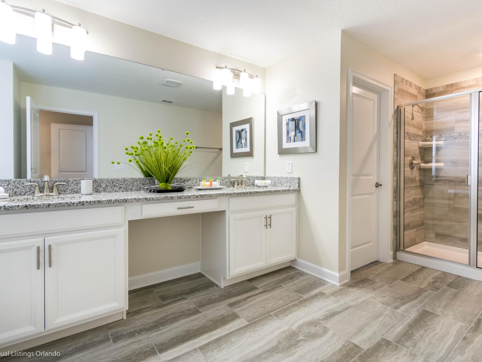 Discover serenity: Our luxurious bathroom boasts a dual vanity and a chic glass-enclosed shower area.