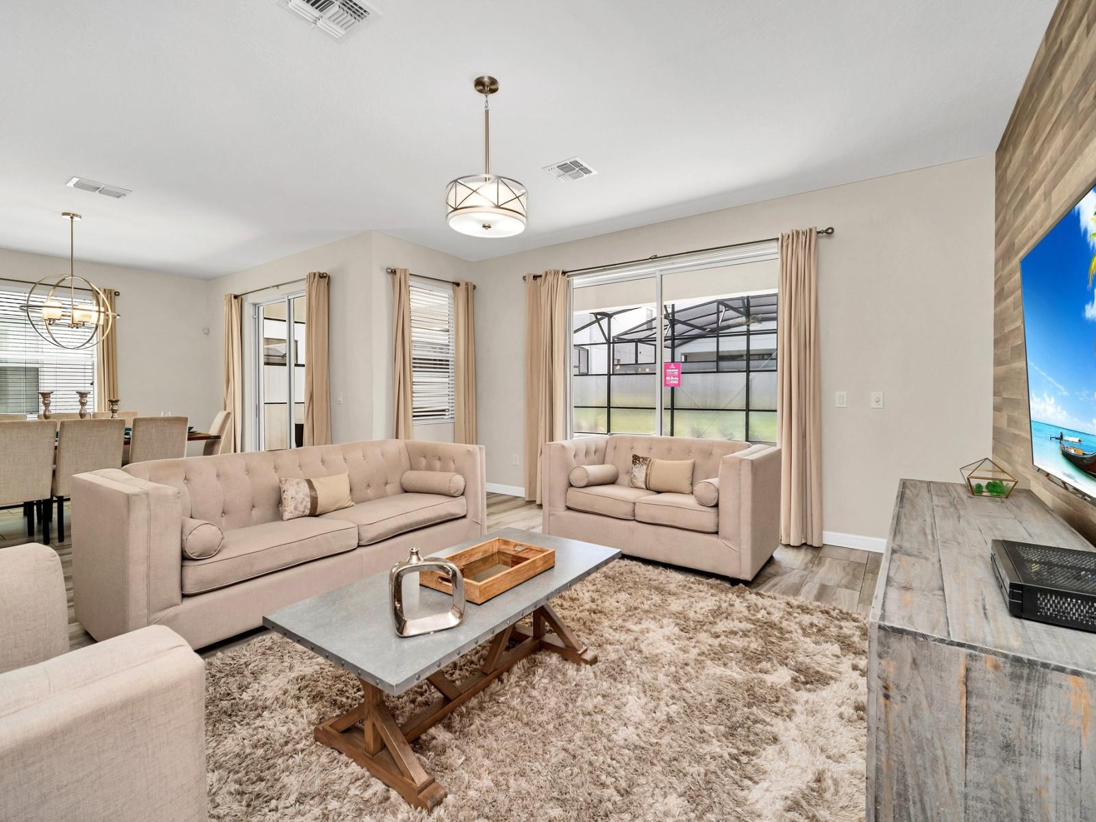 Enchanting living area of the home in Kissimmee Florida - Thoughtful mix of textures, from plush rugs to tasteful throw pillows - Harmonious color scheme with pops of accent colors for visual interest - Comfy sofas and smart TV for relaxation