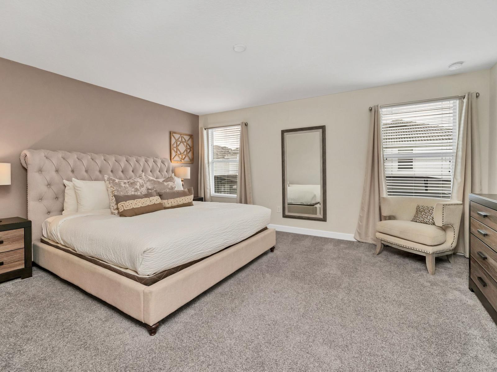 Spacious bedroom of the home in Kissimmee Florida - Comfy king size bed for restful nights - Cozy seating and full length mirror for added convenience - Elegant and coordinated color palette for a cohesive look