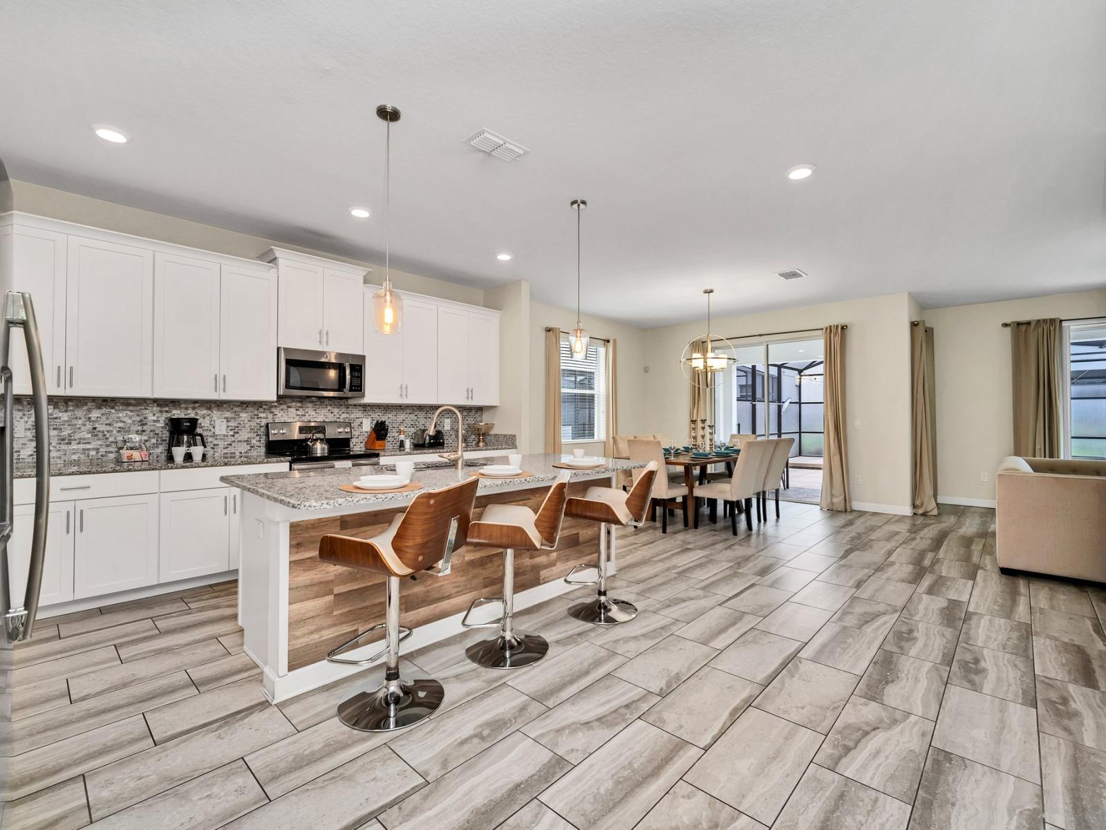 Polished kitchen of the home in Kissimmee Florida - Functional layout designed for efficient meal preparation - Breakfast bar and high chairs - Thoughtful placement of kitchen essentials for easy access