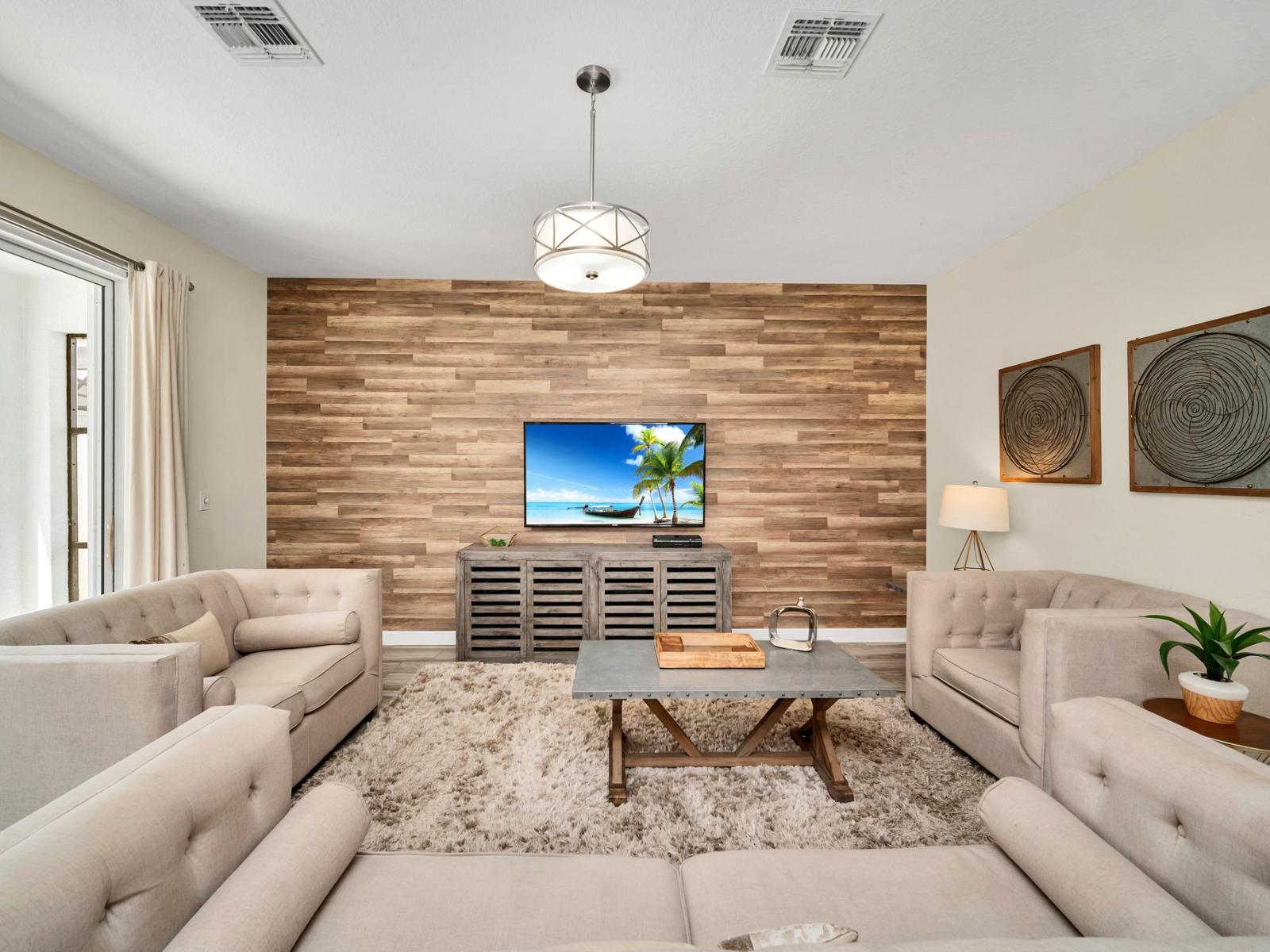 Unwind in our stylish living area with a large TV, creating the perfect space for relaxation and family gatherings. Enjoy your favorite shows or movies in the comfort of this inviting living space.