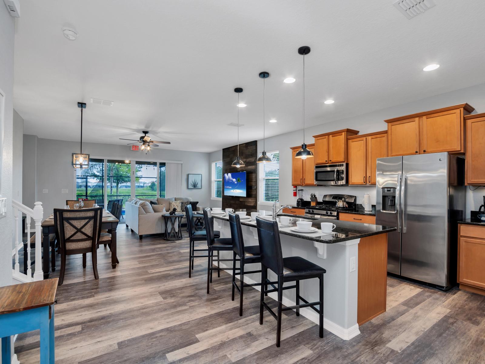 Modern kitchen of the townhouse in Davenport Florida - Sleek stainless steel appliances - Well-lit workspace with strategically placed task lighting - Breakfast bar with high chairs - Smart use of space with versatile storage solutions