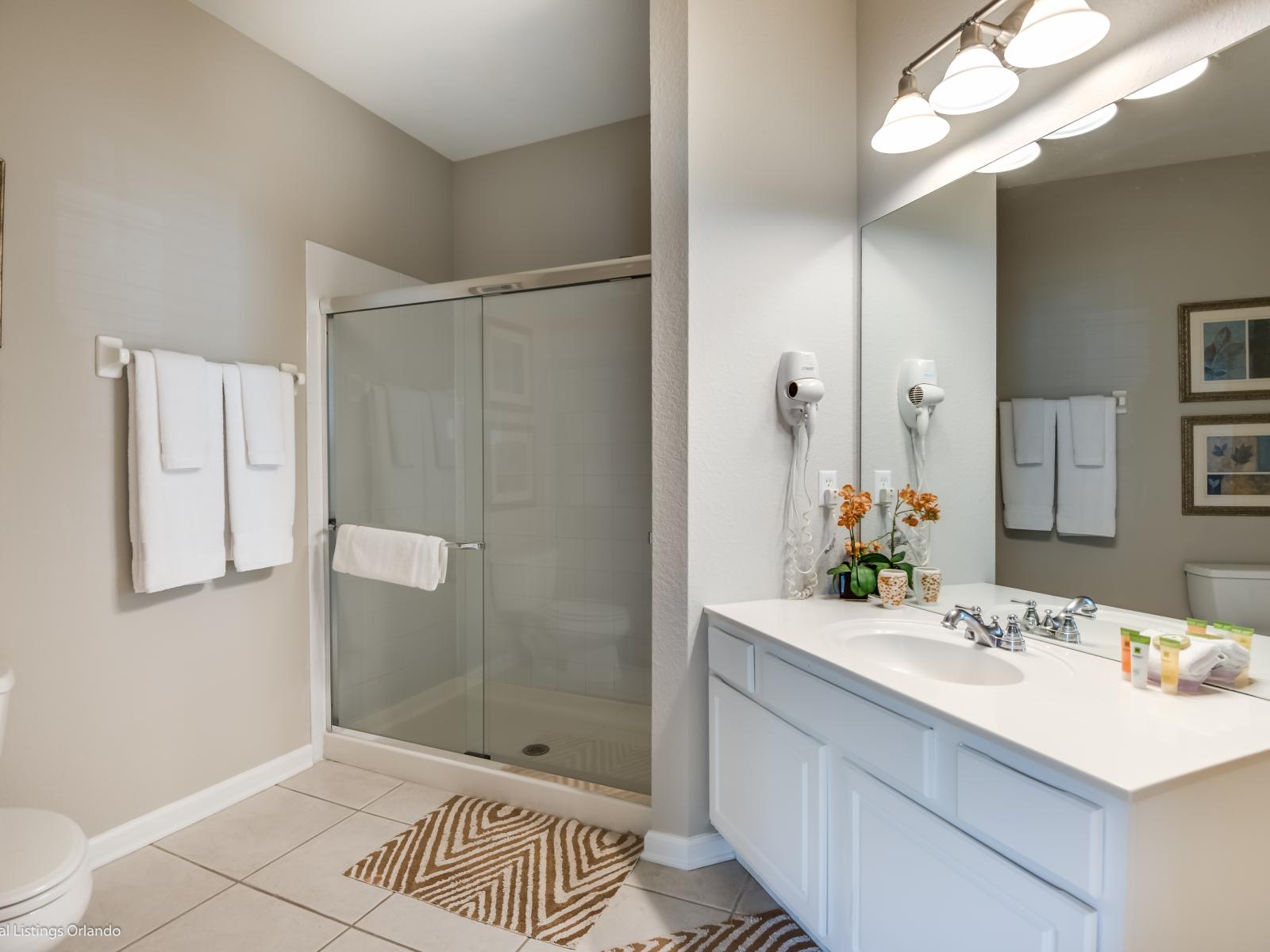 Step into luxury with this bathroom featuring an enclosed shower, providing both style and functionality for a rejuvenating bathing experience.