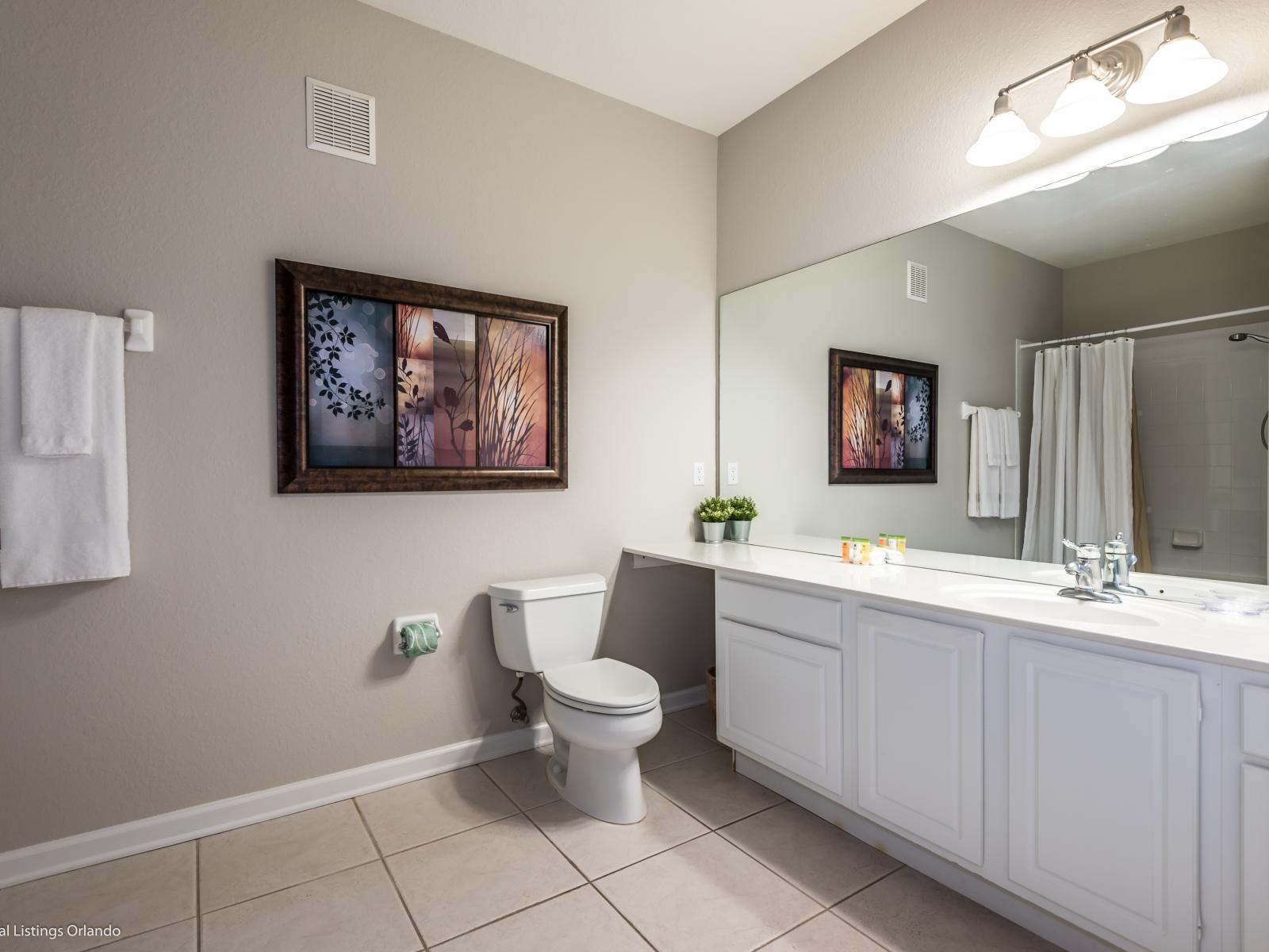 Pamper yourself in style in this elegant bathroom, complete with a chic vanity and a full-size mirror for the perfect finishing touch.