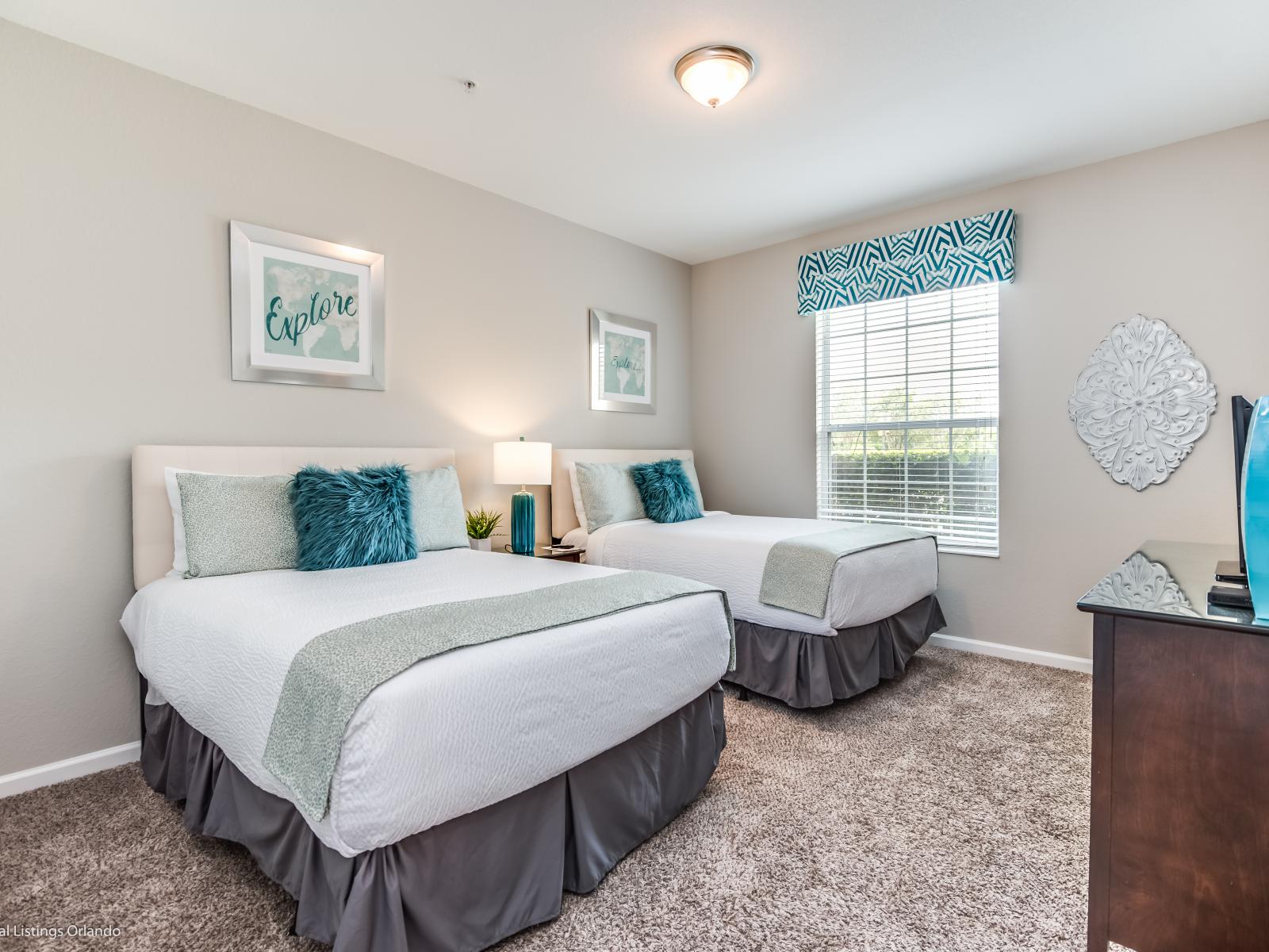 This bedroom with two beds offers a tranquil space for companionship and relaxation, where shared dreams and cherished moments intertwine amidst comfort and warmth.