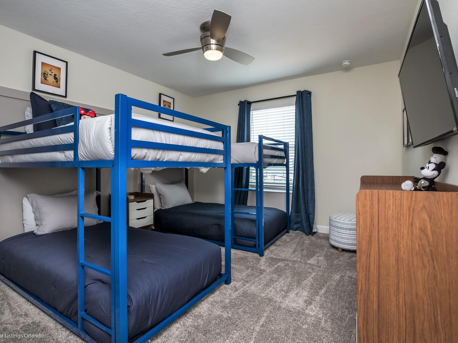 Cozy bedroom of the townhouse in Kissimmee Florida - Equipped with two double deck beds, maximizing sleeping capacity without sacrificing floor space - Smart TV for entertainment - Peaceful surroundings and tranquil Mickey Mouse decor