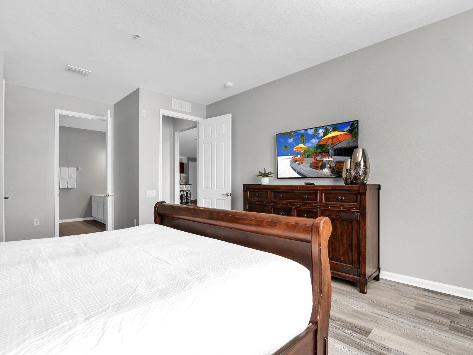 Indulge in relaxation with entertainment at your fingertips in this cozy bedroom featuring a convenient TV setup.