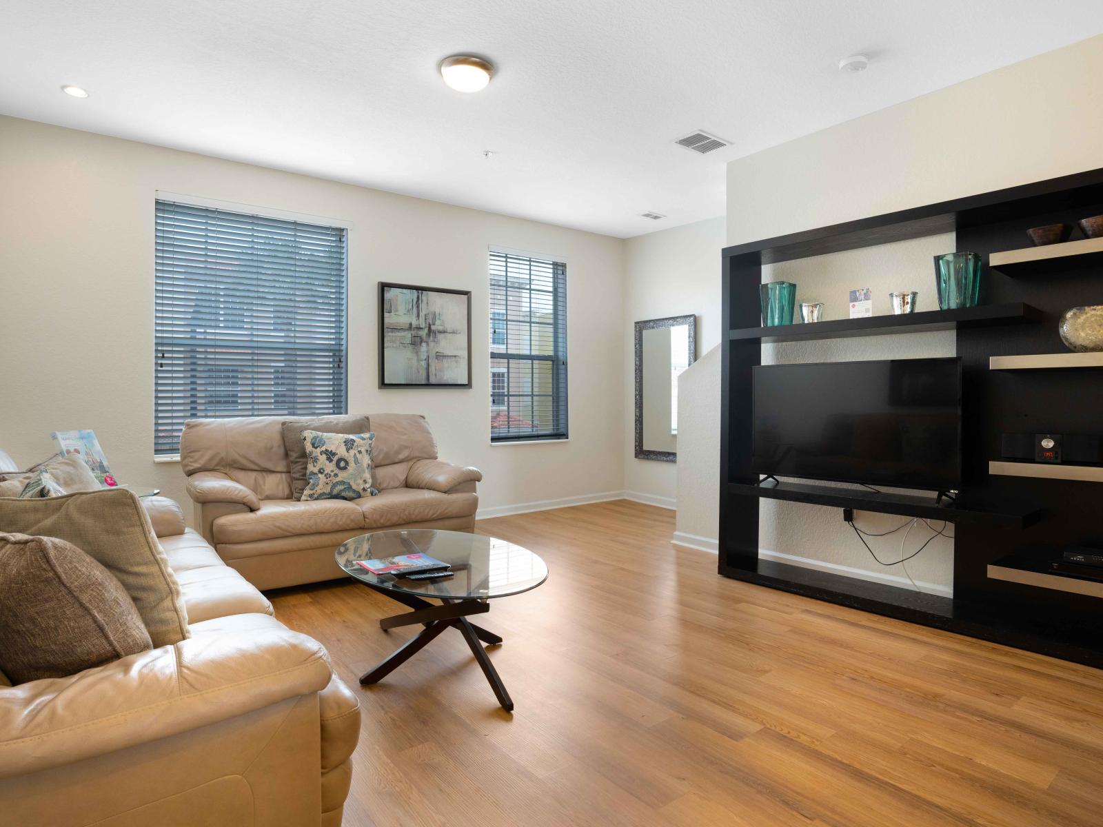 Sublime living area of the townhouse in Orlando - Sleek design and cozy sofas arrangement - Completed with smart TV and Netflix for the entertainment - A quiet space where relaxation meets excitement and comfort - Wooden furnished floor