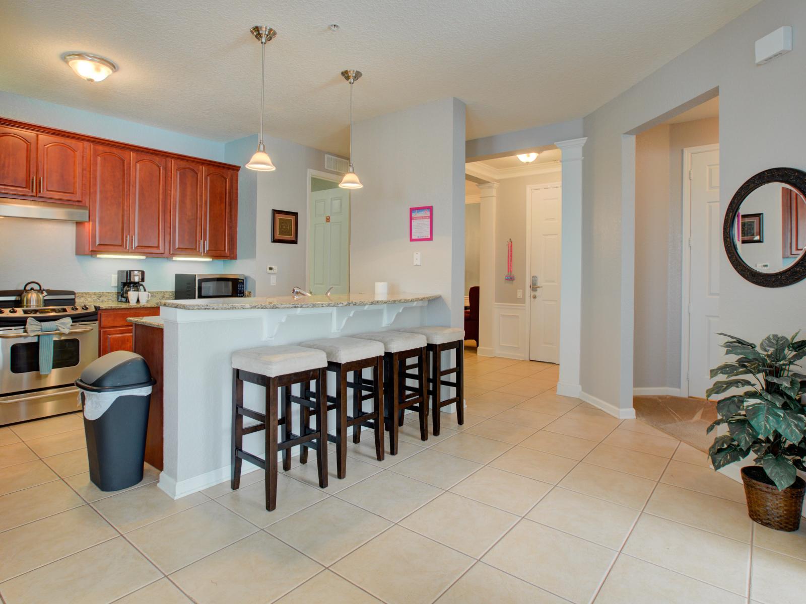 Rustic Charm Meets Modern Convenience: Revel in the Warmth of Wooden Cabinets and Gather 'Round the Counter Table with Sleek High Chairs in Our Kitchen.