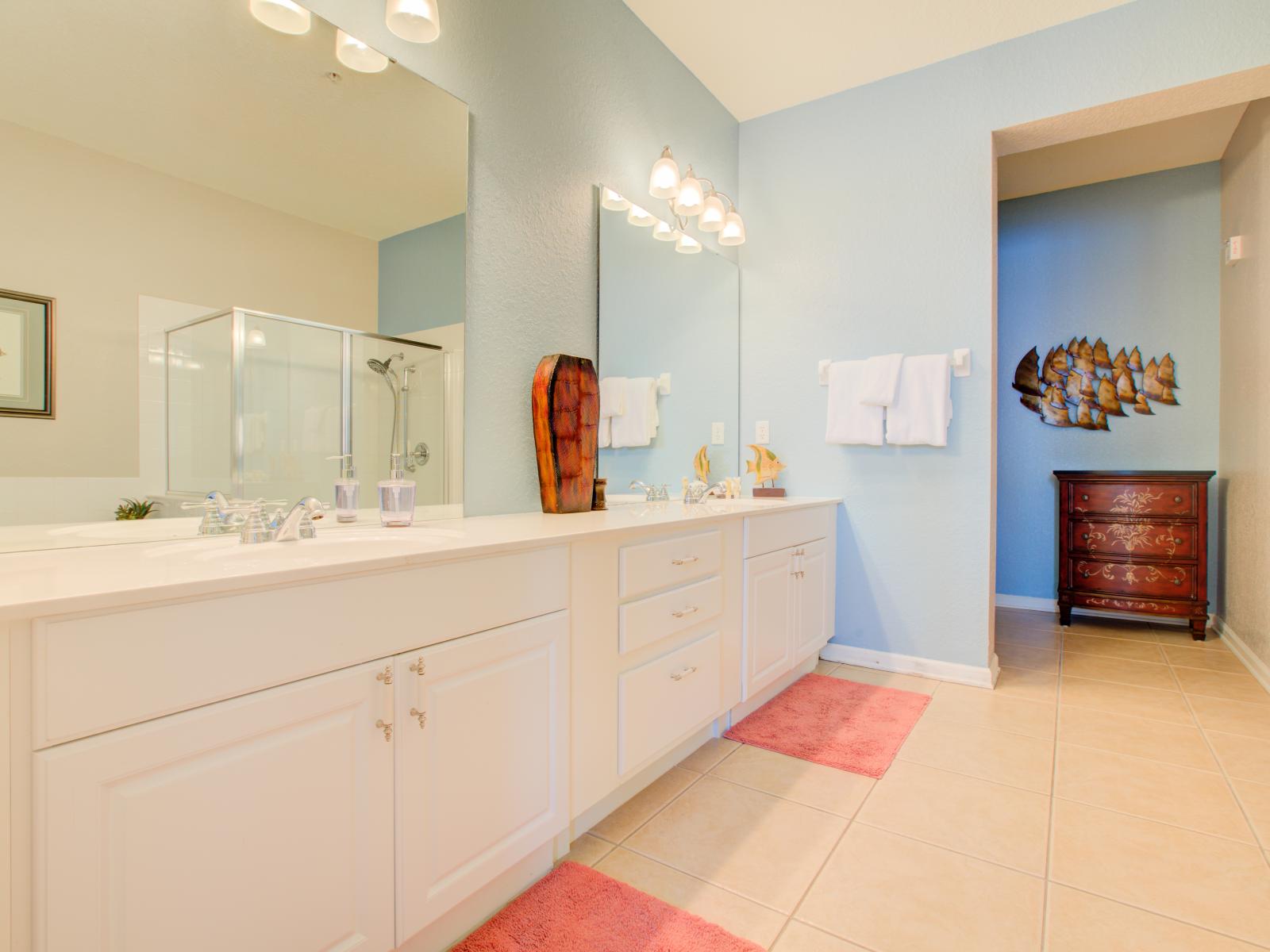 Pamper yourself in style in this elegant bathroom, complete with a chic vanity and a two big sized mirror for the perfect finishing touch.