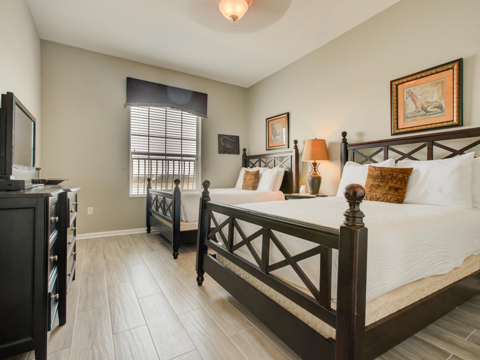 This bedroom with two beds offers a tranquil space for companionship and relaxation, where shared dreams and cherished moments intertwine amidst comfort and warmth.