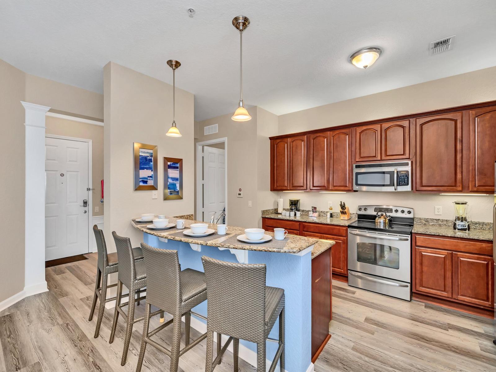 Step into the kitchen with warm brown cabinets, a stylish counter bar, and a fully equipped layout. A space that seamlessly blends rustic charm with modern convenience, promising culinary delights and shared moments in a cozy ambiance.