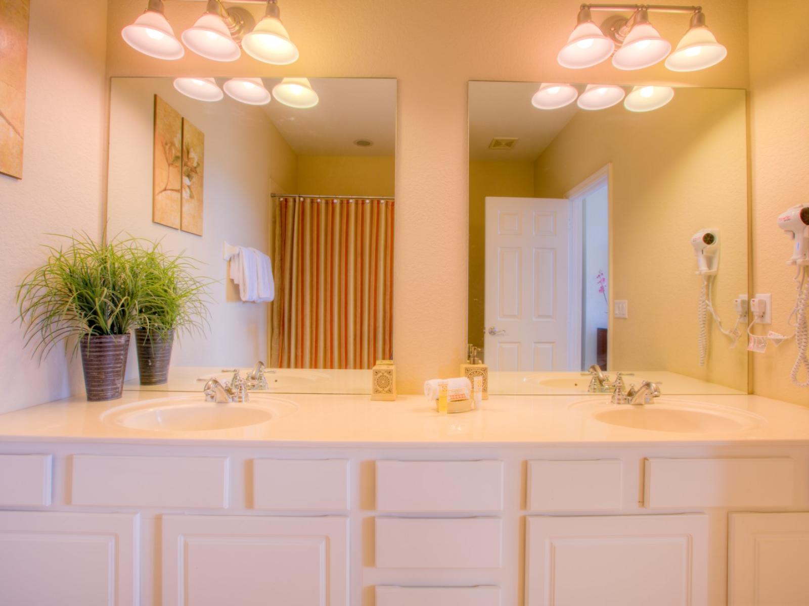 Exclusive Bathroom of the townhouse in Orlando - Lavishly designed bathroom with beautiful vanity - Large size wall mirror with magnificent wall lamps - Sufficient storage space - Availability of Fresh towels -  Neat and clean toilet seat