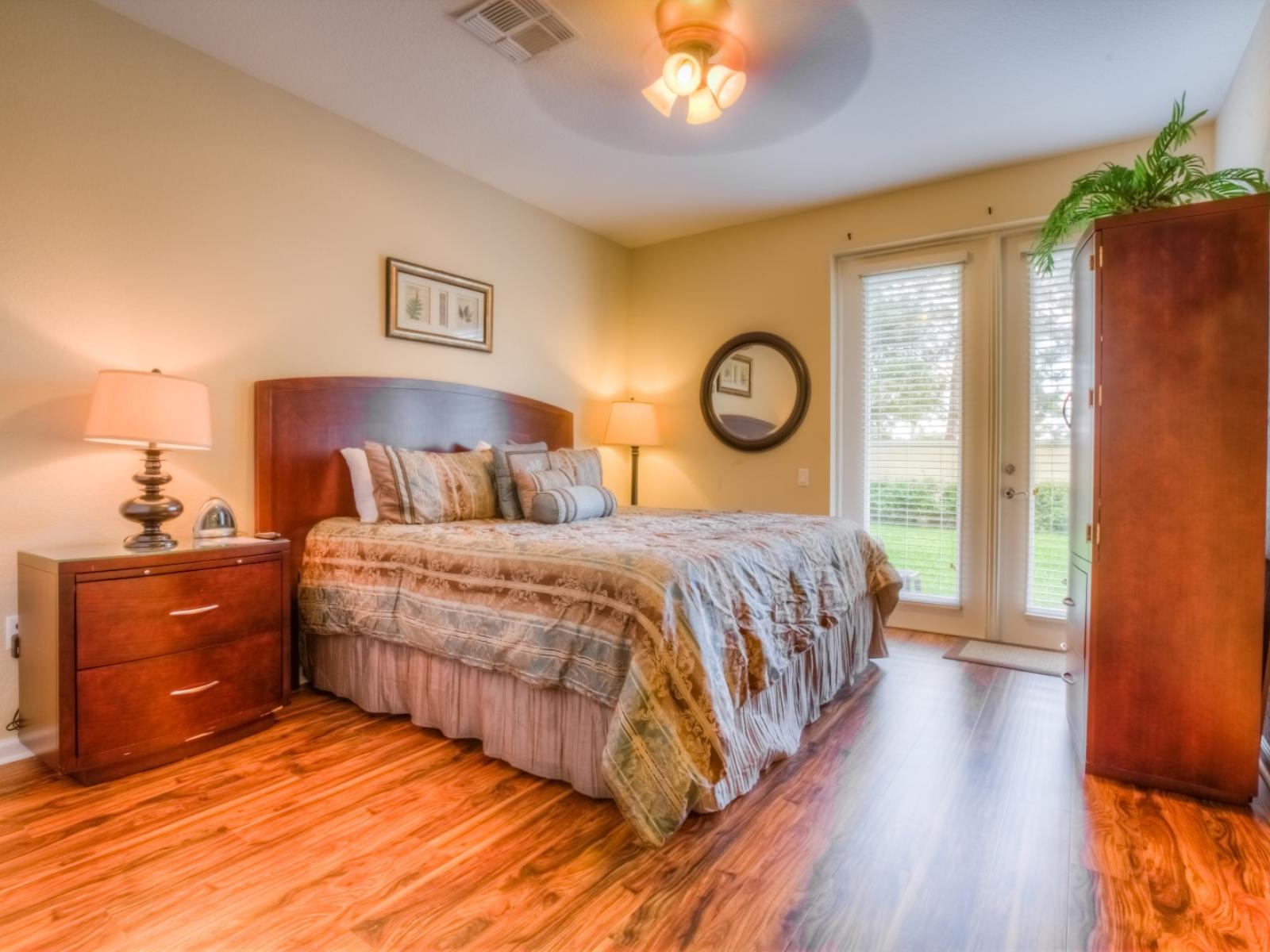 Panoramic Bedroom of the townhouse in Orlando - Stunningly wooden furnished floor -  Amazing and cozy double bed for relaxing - Bedroom with glass doors that leads to the outdoor patio - Majestic table lamps and a roof lamp to increase the lighting