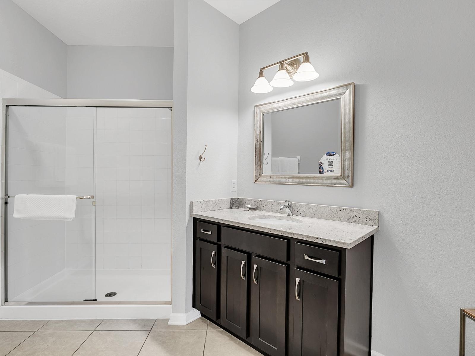 Indulge in luxury and refinement in our serene vanity area and sleek shower enclosure, where rejuvenation meets sophistication.