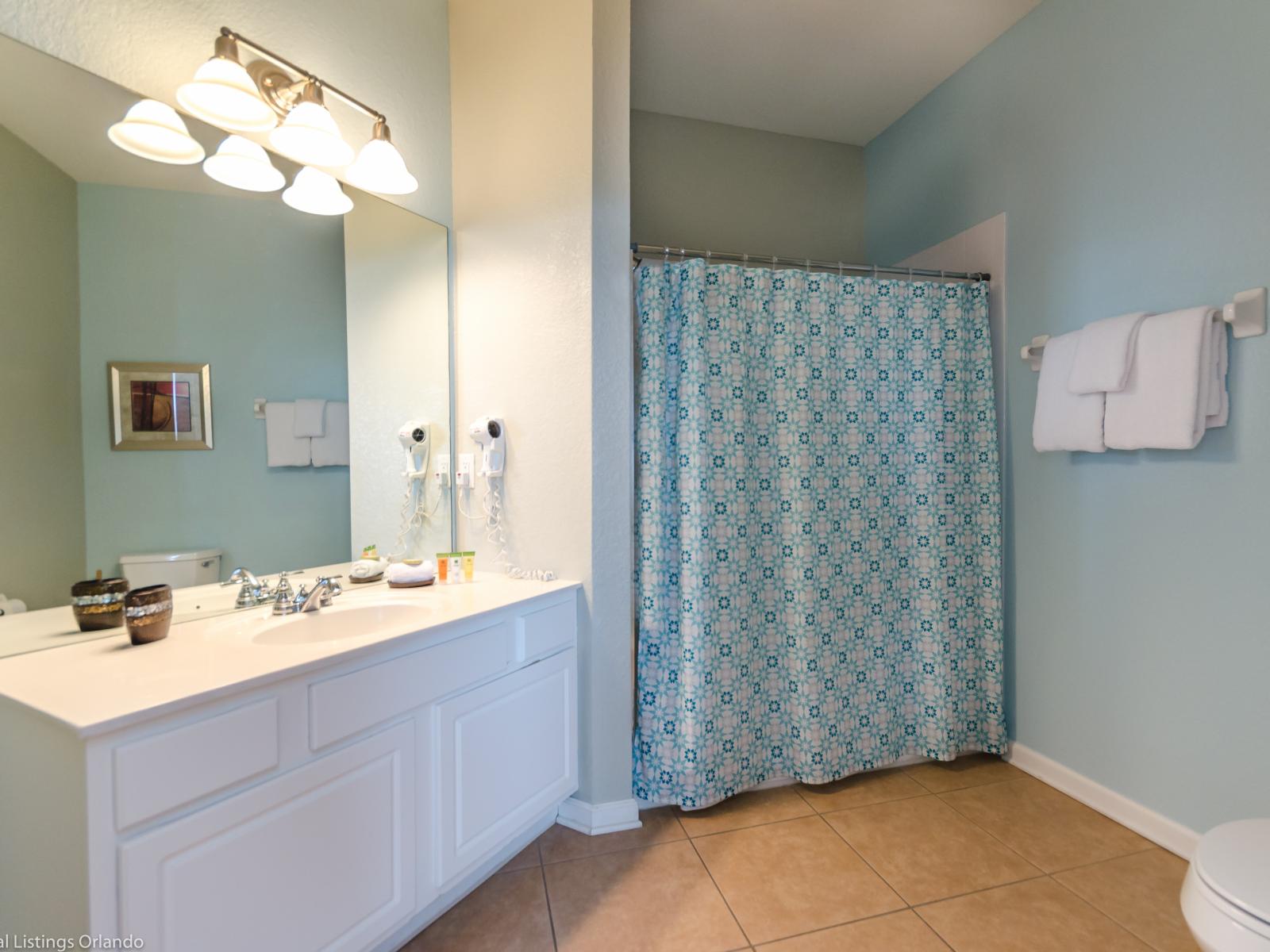 Our vanity area seamlessly leads to the shower space, offering a graceful transition from grooming to relaxation, where every detail enhances your sense of comfort.