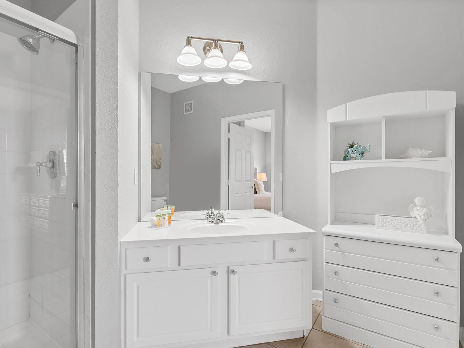 - Polished Bathroom of the condo in Orlando Florida - Unwind in style in relaxing bathroom - Elegant glass cabin shower area - Chic Vanity with large mirror and lamp - Beautiful wardrobe with sufficient storage space