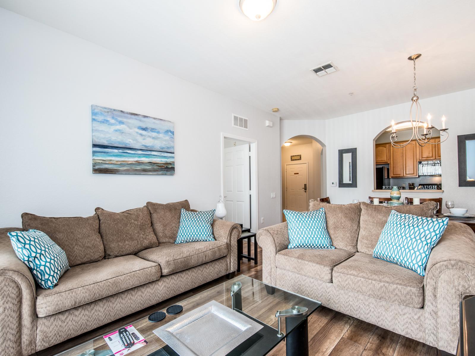 This cozy living area is strategically located beside the dining table and kitchen, providing effortless access to the private balcony for relaxing outdoor moments.