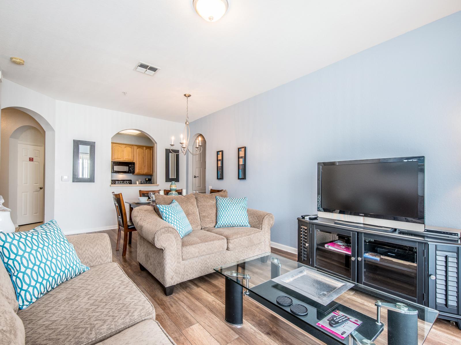 The simple yet inviting living area sits conveniently beside the dining table and kitchen, providing easy access to the private balcony for a seamless indoor-outdoor living experience.