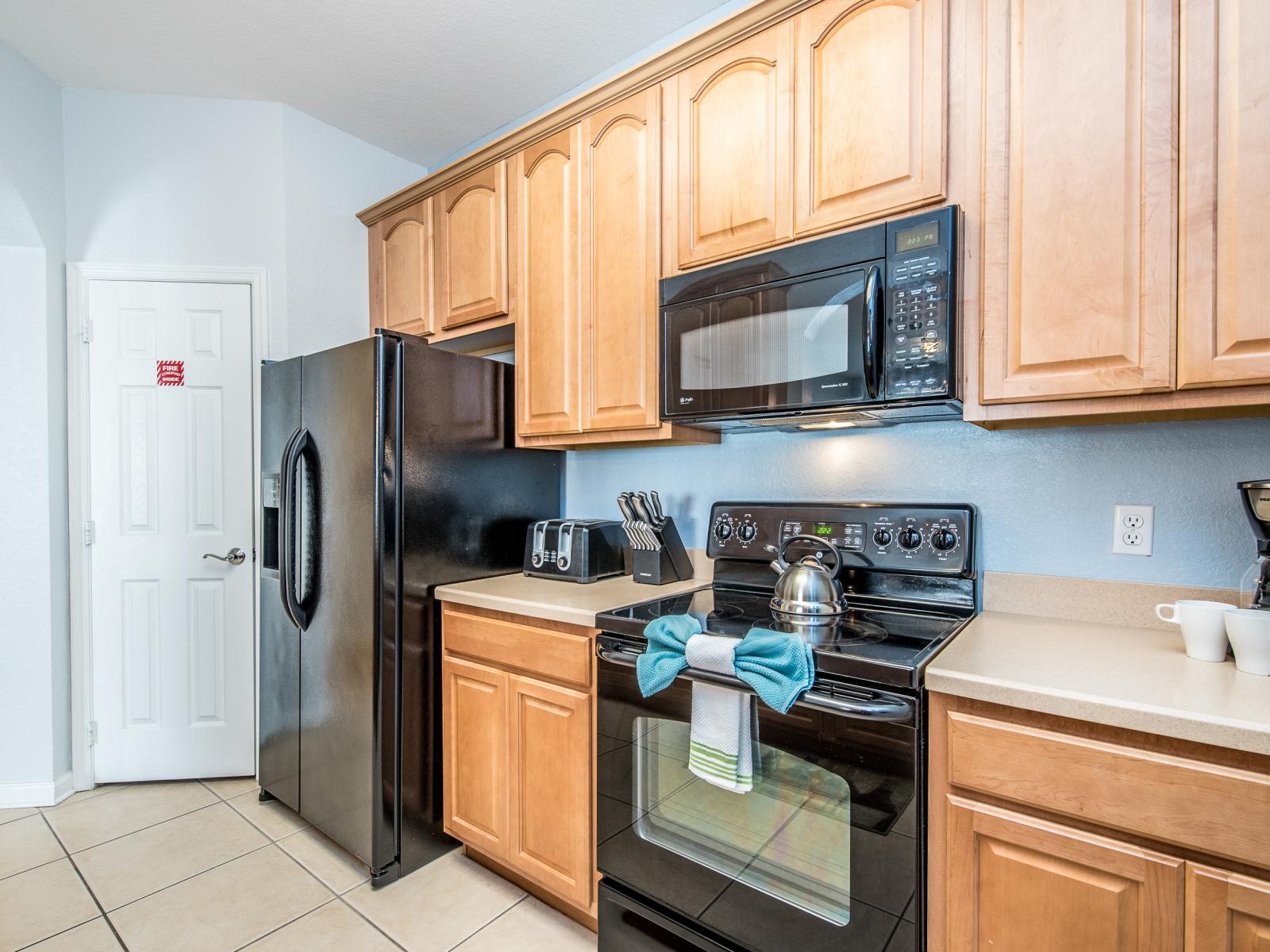 Discover a fully furnished kitchen equipped with a spacious refrigerator, providing ample storage for all your culinary delights and refreshments.