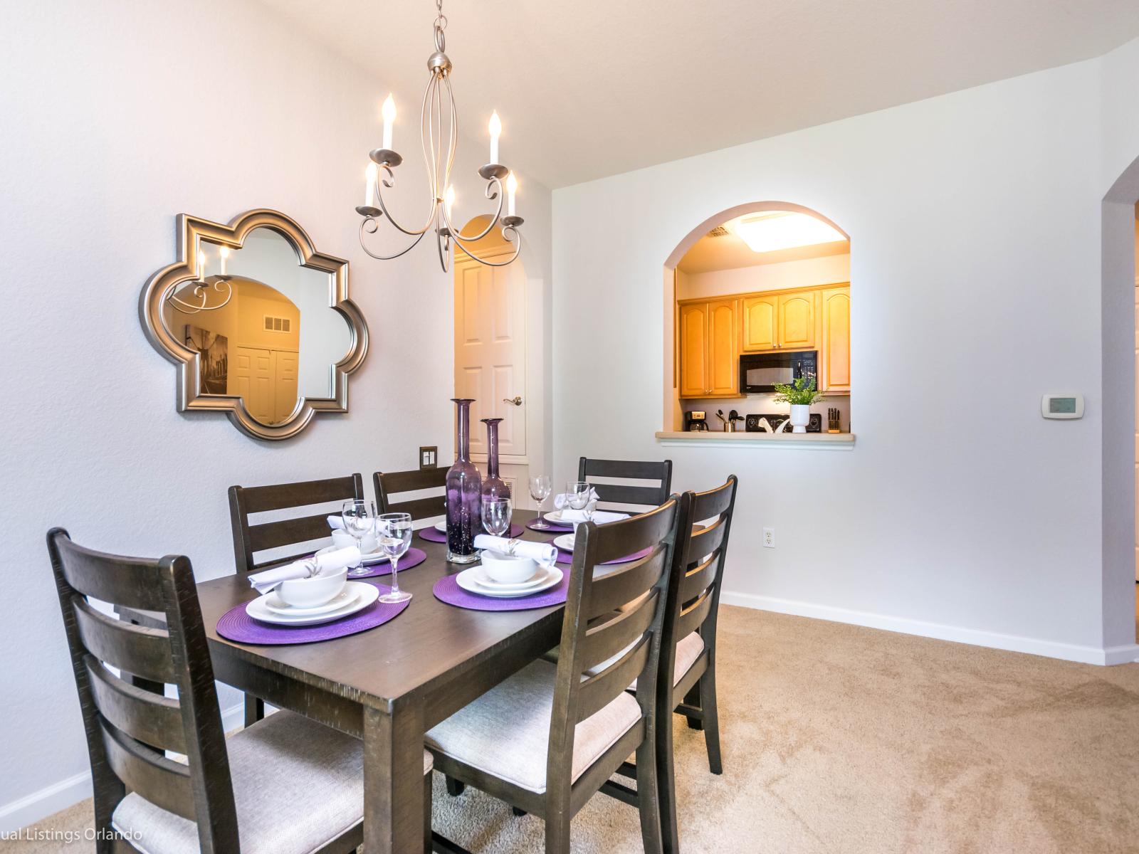 Chic dining area of the condo in Orlando Florida - Sophisticated design with a blend of modern and classic elements - Beautiful chandelier - Dining for 6 persons - Artfully arranged table settings for a touch of elegance