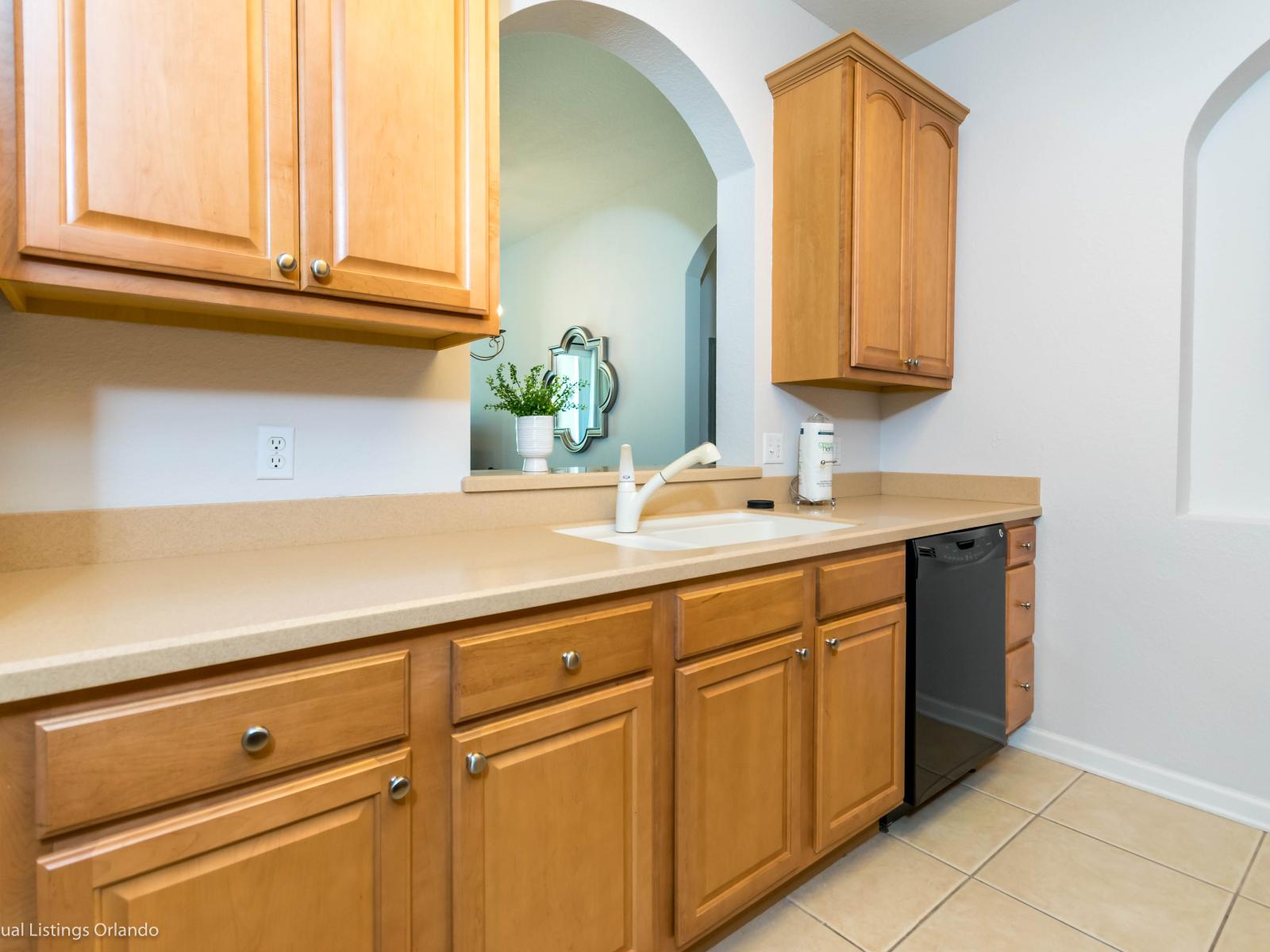 Alluring kitchen of the condo in Orlando Florida - Well-lit workspace with strategically placed task lighting - Elegant and coordinated color palette for a cohesive look