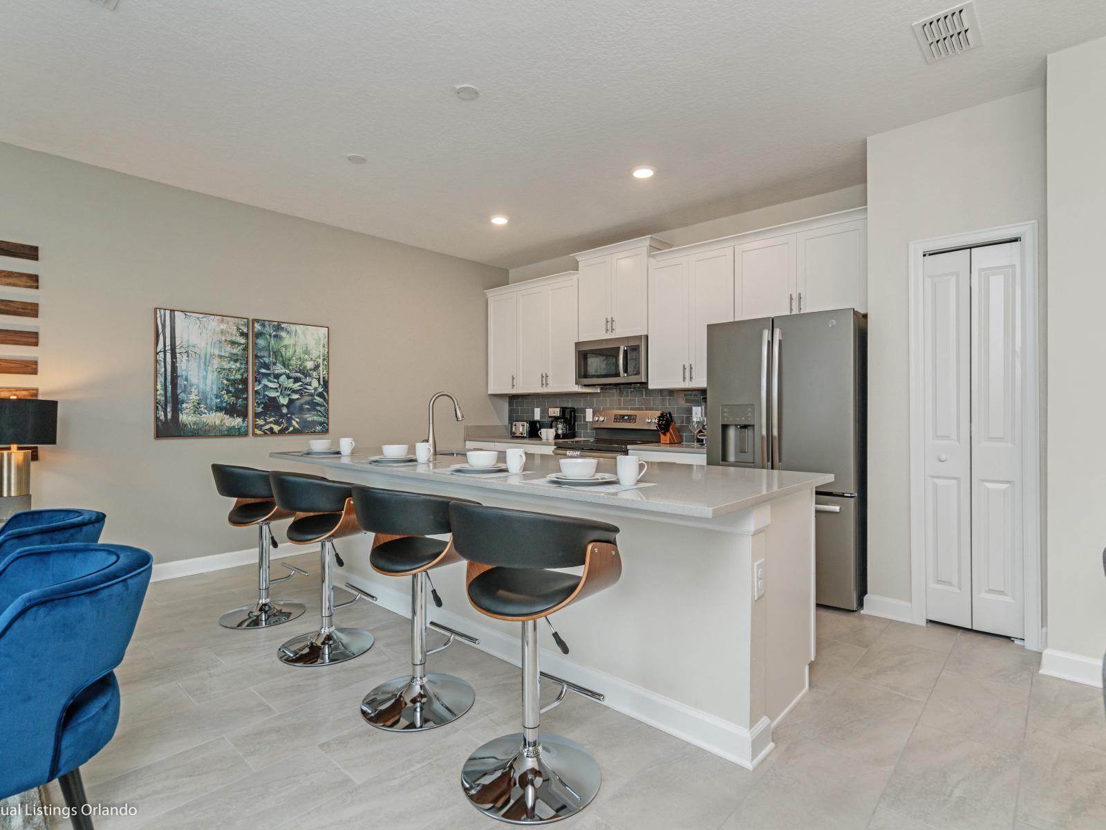 Modern Kitchen of the Townhouse in Kissimmee Florida - Sleek stainless steel appliances - High Chairs and Breakfast Bar - Smart use of space with versatile storage solutions