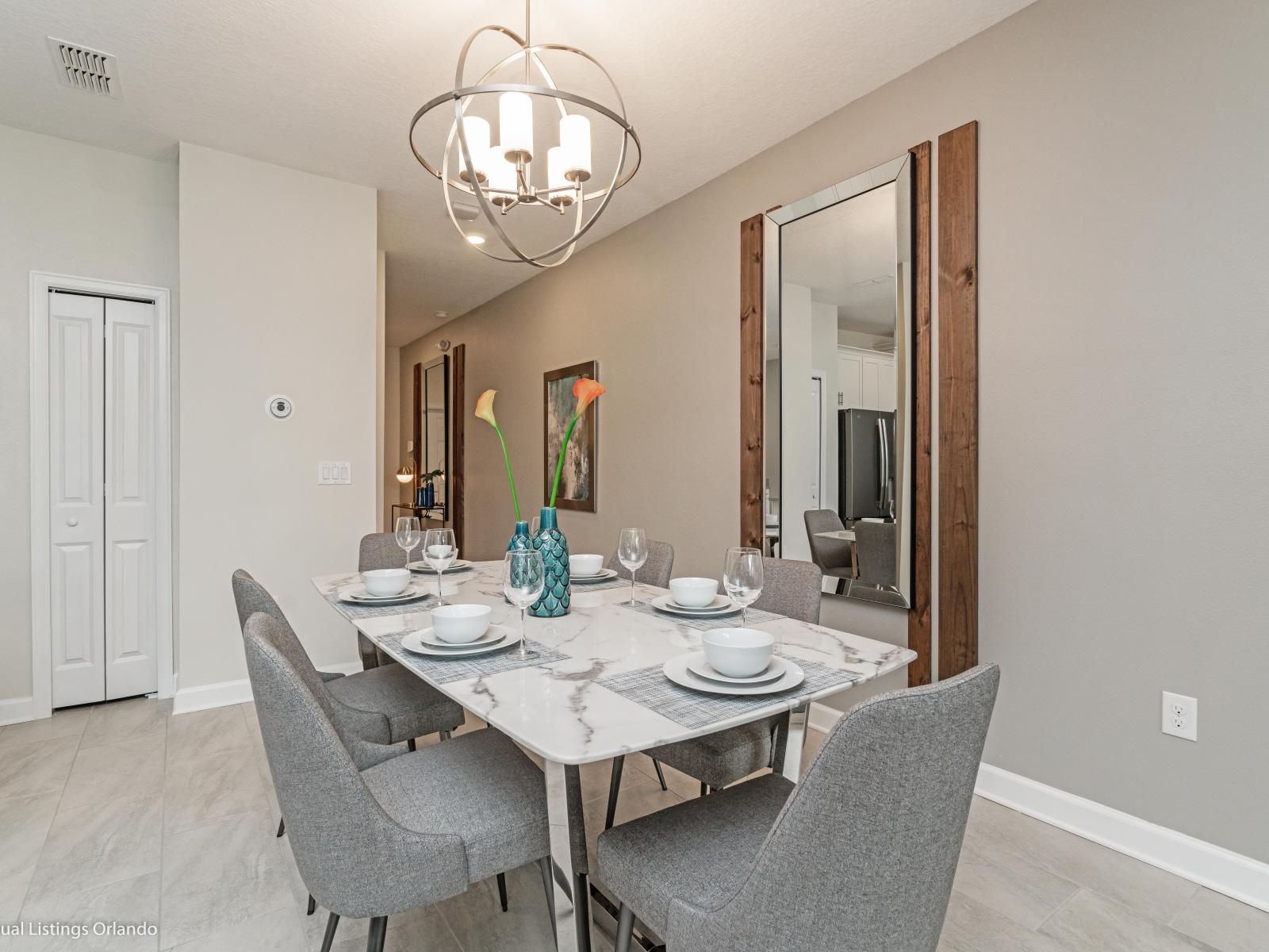 Luxe Dining Area of the Townhouse in Kissimmee Florida - Strategic use of mirrors to enhance the perception of space - Dining for 6 Persons - Chic dining area featuring a stylish Marble Accent table and contemporary seating