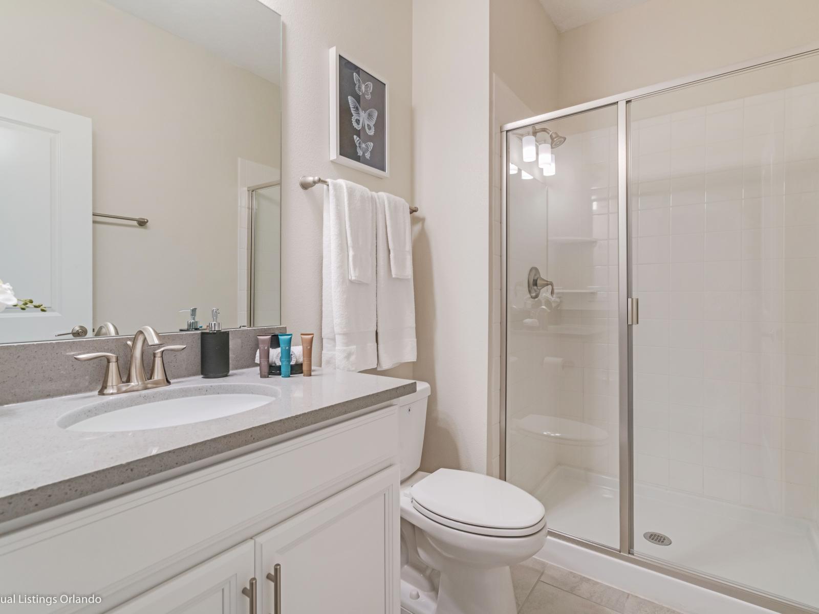 Polished Bathroom of the Townhouse in Kissimmee Florida - Effortlessly stylish with a vanity and chic accessories - Glass-enclosed shower area