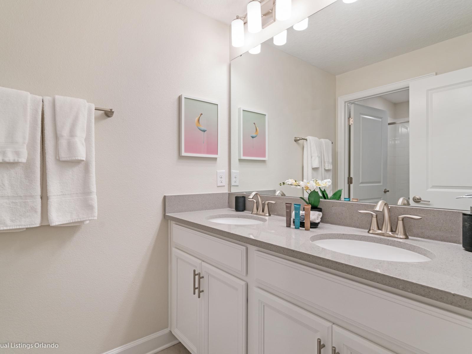 Polished Bathroom of the Townhouse in Kissimmee Florida - Chic design featuring a sleek double vanity and upscale lighting - Well-lit space with strategically placed mirrors for a spacious feel