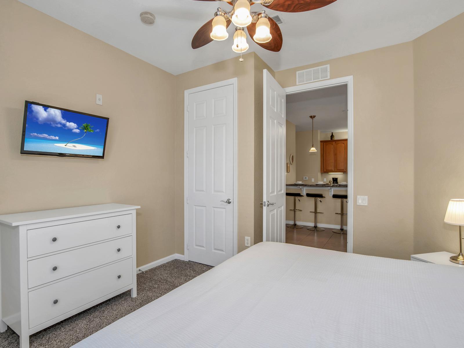 This cozy bedroom adorned with an accent chair and a ceiling fan, perfect for enjoying moments of tranquility.