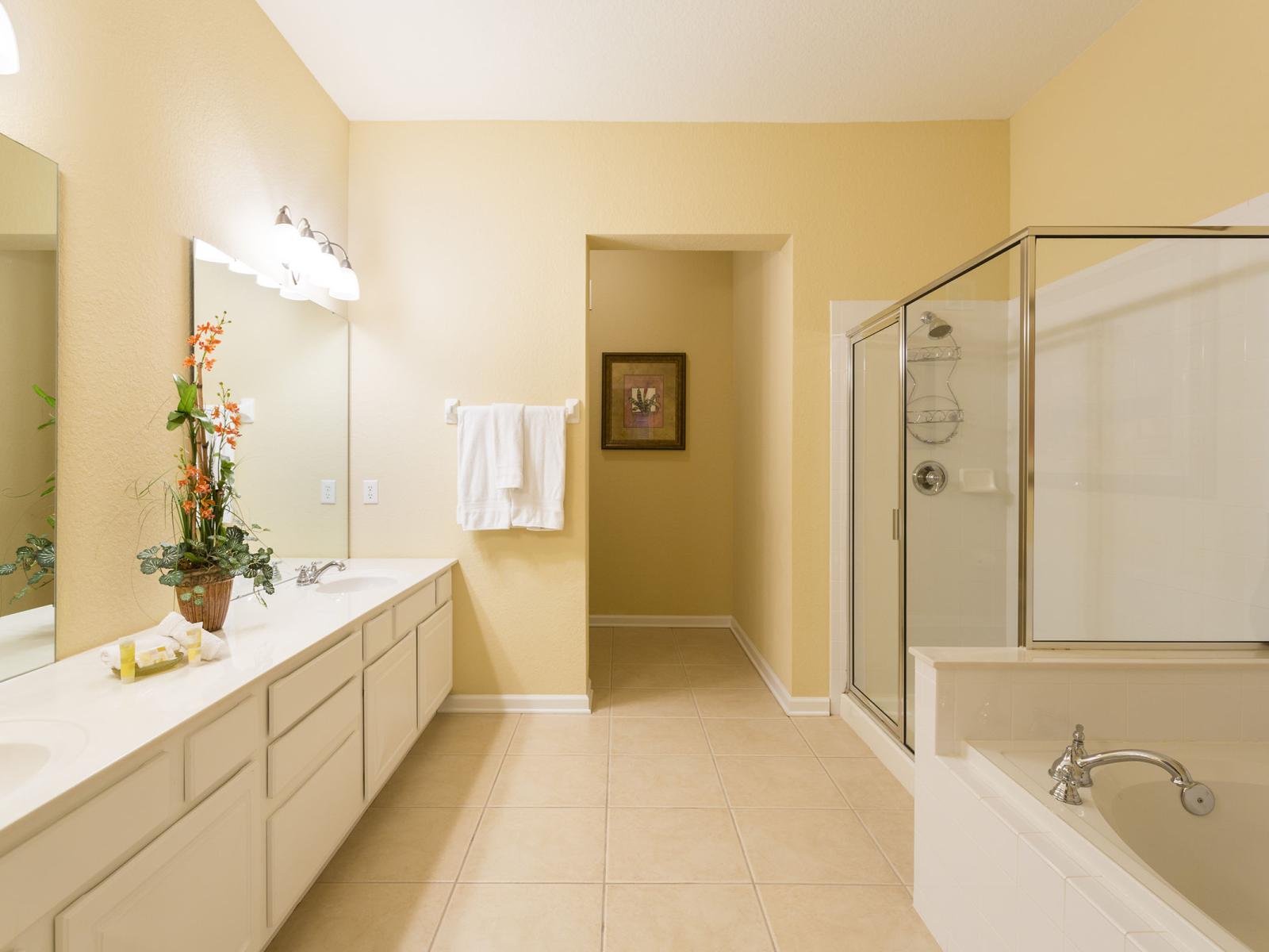 Luxurious Bathing Haven of the condo in Orlando - Showcasing a walk-in shower and inviting tub for a pampering escape like no other - Glorious Twin sink vanity - Availability of fresh towels along with all bathroom amenities - Plenty  storage space