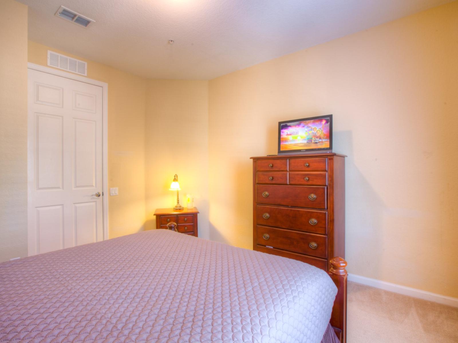 Indulge in relaxation with entertainment at your fingertips in this cozy bedroom featuring a convenient TV setup.