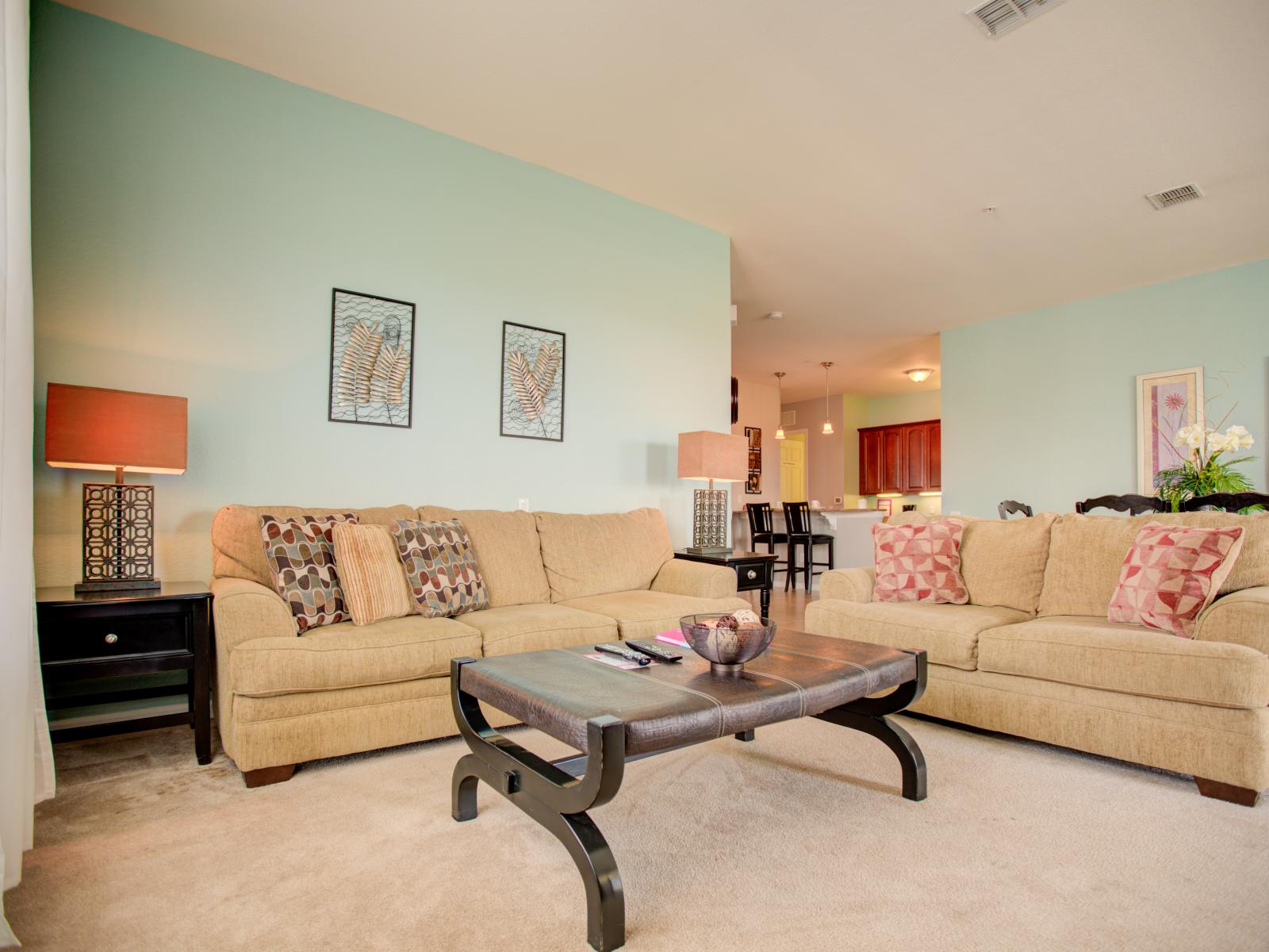 - Center stage living area of the condo in Orlando - Inviting you to relax, connect, and create memories in the lap of spacious elegance. - Featuring comfy sofas to relax - Majestic and smart decor throughout the space - Carpeted floor