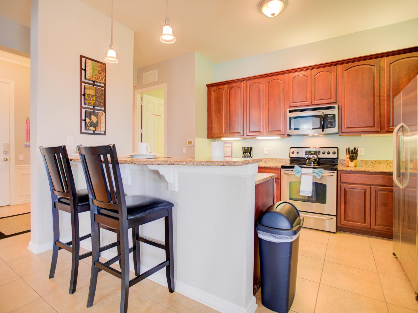 - Glorious kitchen of the condo in Orlando - Fully equipped with all kitchen accessories and stainless steel appliances - Availability of comfy high chairs at the breakfast bar - Elegant lighting  - Plenty of storage space