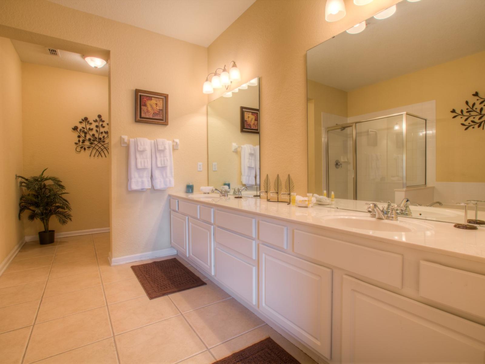 Well-designed bathroom of the condo in Orlando - Beautiful twin sink vanity area- a haven for pampering and self-care. - Availability of fresh towels and all bathroom amenities - Glass enclosed shower area and a cozy bathtub